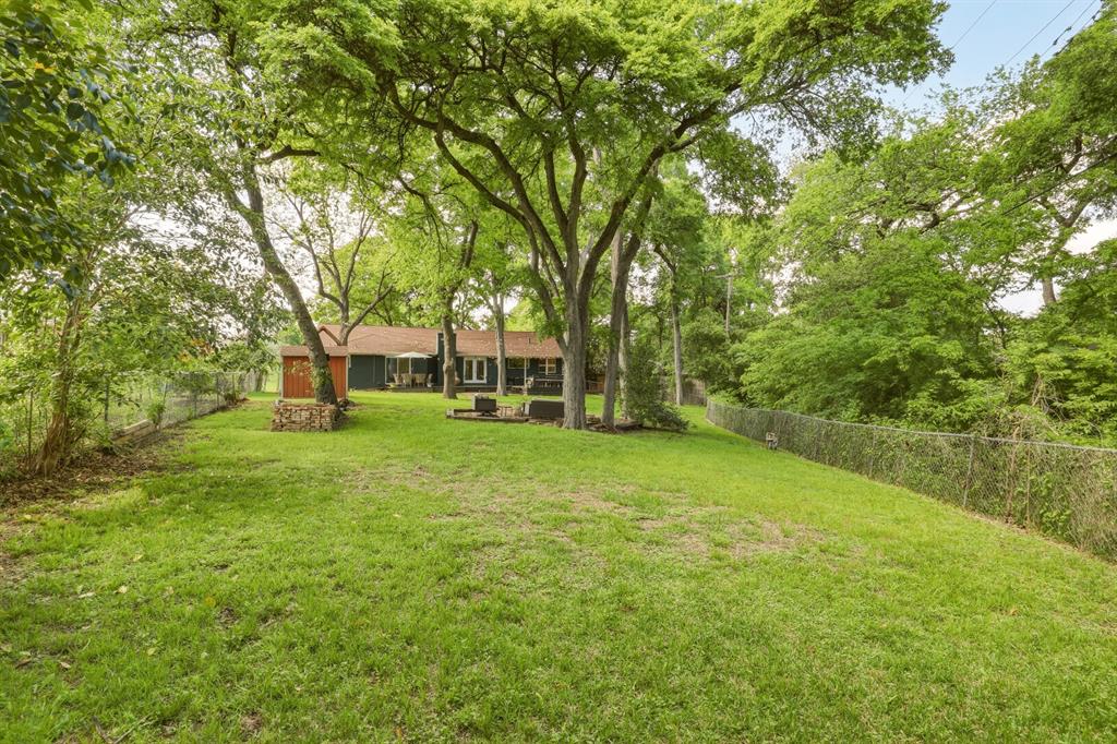 Stop Scrolling!  This house is not to be missed.  !!OPEN SATURDAY, JULY 25TH 2:00-4:00!!  Sitting on a rare 80x205 lot, this home offers an open-concept layout and is designed for effortless living. The kitchen, with its inviting breakfast bar, farmhouse sink, and wood countertops, provides stunning views of the lush backyard. The dining area flows seamlessly into the living room, where French doors open wide to bring the outdoors in. A brick wood-burning fireplace and gorgeous hickory floors add warmth throughout, while natural light floods every room.

The primary suite is your personal escape, complete with custom wood paneling and a spa-like bath featuring a walk-in closet, soaking tub, and separate standing shower. Both bathrooms have been beautifully updated, and plans to expand to a three-bedroom layout are included and ready to convey with the home.

The backyard is nothing short of magical. Imagine hosting unforgettable gatherings surrounded by party lights and built-in speakers that set the perfect mood. Follow the charming stone walkway to a custom fire pit and landing—ideal for cozying up on crisp evenings under the stars. This will be the place all of your friends and family will want to gather! 

Extensive updates in 2024 include: new roof, gutters, garage door and unit, back deck and updated exterior electrical.  Sellers are offering a $5,000 credit toward buyers closing costs with an acceptable offer. 

All of this in an unbeatable location—just a short walk or bike ride to White Rock Lake, perfect for outdoor enthusiasts.