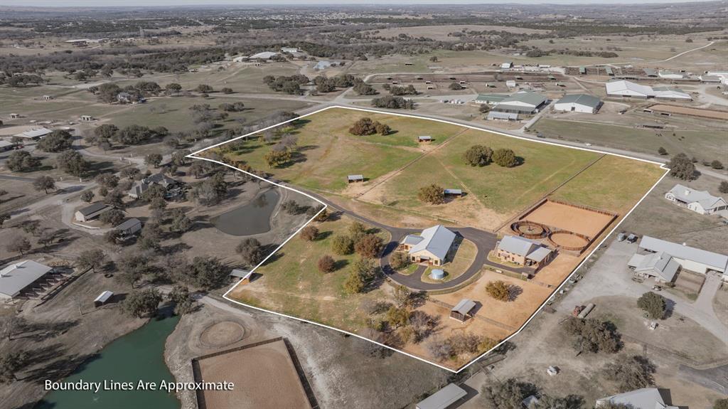 Silverado on the Brazos truly has it all — refined country living with convenient access to Weatherford, Granbury, and Fort Worth. This exceptional equestrian estate spans 18 acres in the highly sought-after Silverado on the Brazos community and is thoughtfully designed. Ideal for trainers, or serious horse enthusiasts. The property features a custom-designed, rustic-finished 1-bedroom, 1-bath, 688 sq ft Barn dominium, a 120’ x 120’ arena, a premium Trojan 60’ panel walker, and a 60’ round pen for additional training space. The land is fully fenced and cross-fenced with pipe no-climb fencing, offering excellent functionality and safety. Eight well-appointed turnouts, each equipped with 16’ x 30’ loafing sheds and automatic water, provide outstanding pasture management. Income-producing opportunities include three additional on-site apartments, ideal for staff housing or rental income. The ranch is further supported by a 10,000-gallon holding tank, ensuring reliable water capacity year-round. Additional improvements include a state-of-the-art 88’ x 40’ horse barn with eight 14’ x 12’ stalls, a feed room, tack room, and wash rack with mare stocks. A spacious 40’ x 60’ hay barn with ample storage completes the working infrastructure.This turnkey equestrian facility offers rare scale, functionality, and versatility in one of Parker County’s premier horse communities — just minutes from Weatherford with easy access to Fort Worth.