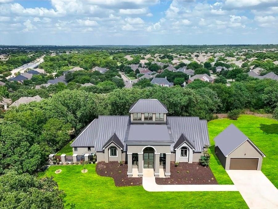 Luxury remodeled estate on nearly 4 private acres in Keller ISD, offering a rare combination of upscale living, scenic elevation, custom design, and future development potential in one of Keller’s most desirable acreage settings. Tucked among prestigious large-lot properties, this exceptional hilltop retreat delivers privacy, breathtaking treetop views, and a peaceful estate atmosphere just minutes from Southlake, shopping, dining, and major highways. The beautifully remodeled custom home features 4 bedrooms, 3 baths, and a spacious light-filled layout enhanced by expansive windows, designer finishes, and numerous custom touches throughout. Thoughtfully updated in recent years, the home blends distinctive architecture with comfortable everyday functionality, creating inviting living spaces ideal for entertaining and family living. Rich textures, custom details, and natural light combine to give the home warmth, character, and a truly one-of-a-kind feel. The oversized living areas flow seamlessly while capturing stunning views of the surrounding acreage from nearly every room. The flexible floorplan offers both privacy and versatility, making the property ideal for multi-generational living, luxury estate living, or buyers seeking space rarely found in Keller. The land itself is an extraordinary asset. Nearly four elevated acres provide unmatched privacy, mature trees, rolling topography, and endless future possibilities, including potential for a second residence, guest house, luxury compound, or possible subdivision opportunities subject to buyer verification. An oversized detached garage offers additional flexibility for car enthusiasts, workshop space, hobbies, fitness, or storage. Whether enjoyed as a private luxury retreat, long-term investment, or future development opportunity, this property stands apart for its combination of remodeled living, custom character, acreage, elevation, and future potential.