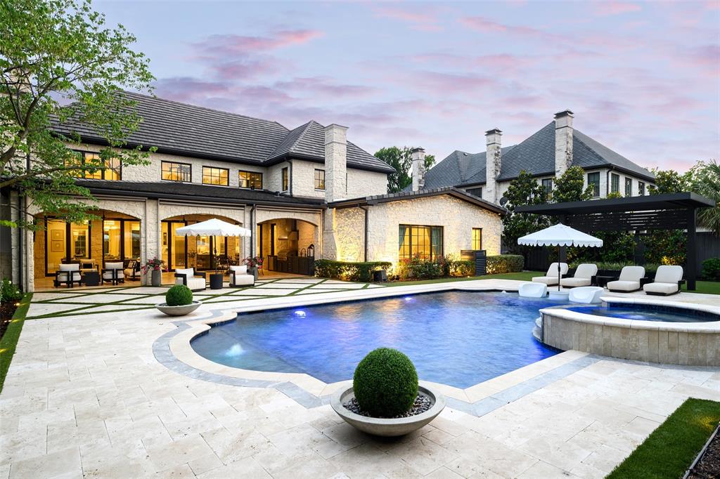 Positioned within one of Preston Hollow's most sought after enclaves, this exceptional custom estate offers 7,584 square feet of refined luxury with 5 bedrooms, 6.2 baths, private elevator, and a 3 car garage. Behind its striking stone façade, the residence showcases timeless architecture, impeccable craftsmanship, and a thoughtfully curated floor plan designed for both grand scale entertaining and elevated everyday living. A dramatic two story foyer with sweeping staircase sets the tone, opening to sophisticated formal living and dining spaces accented by rich millwork, designer lighting, soaring ceilings, and exquisite finishes throughout. The kitchen is a true showpiece, featuring an oversized center island, dual professional grade thermador appliances, extensive custom cabinetry, and exceptional prep and storage space. The kitchen flows seamlessly into the living room, where a stunning fireplace and walls of glass create an inviting gathering space filled with natural light. The first floor primary suite serves as a private sanctuary, complete with a sitting area, fireplace, spa inspired bath featuring dual vanities, a soaking tub, oversized marble shower, and an extraordinary custom wardrobe room. Upstairs, spacious ensuite bedrooms provide comfort and privacy, while an expansive game room, dedicated media room with wet bar, fitness studio, and elevator access offer exceptional flexibility for recreation and relaxation. The outdoor experience is equally remarkable. Designed as a private resort retreat, the backyard features a spectacular pool and spa, multiple gathering areas, and a covered entertaining pavilion complete with outdoor kitchen, fireplace, and dining area. An outdoor sauna further elevates the wellness experience. Combining timeless architecture, exceptional craftsmanship, resort caliber amenities, and an address among Preston Hollow's most prestigious residences, this extraordinary estate embodies sophisticated Dallas luxury at its finest.