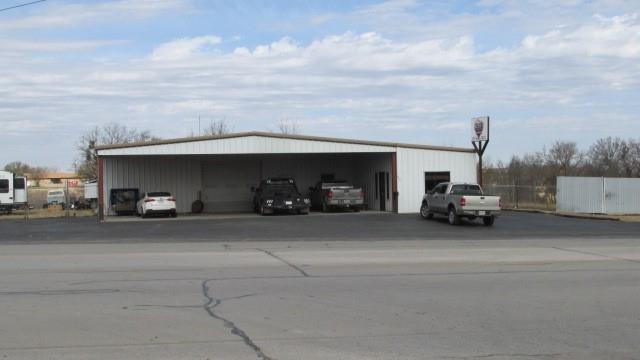 Location store front on Hwy 377 North.  Building heavily insulated I Beam and C Beam construction.  7,292 SF enclosed space (6,600 SF shop, 692 SF air conditioned office and reception area).  1,600 SF covered parking.  Auto paint booth.  Current use is an automotive restoration business.  Multiple overhead doors create ingress and egress on three sides of the building.  Fenced on three sides.   Current lease expires May 31, 2022.  LISTING AGENT IS RELATED TO SELLER.  Photos showing space before lease are dated 2019.  Current photos, 2022, show space being used for auto restoration.