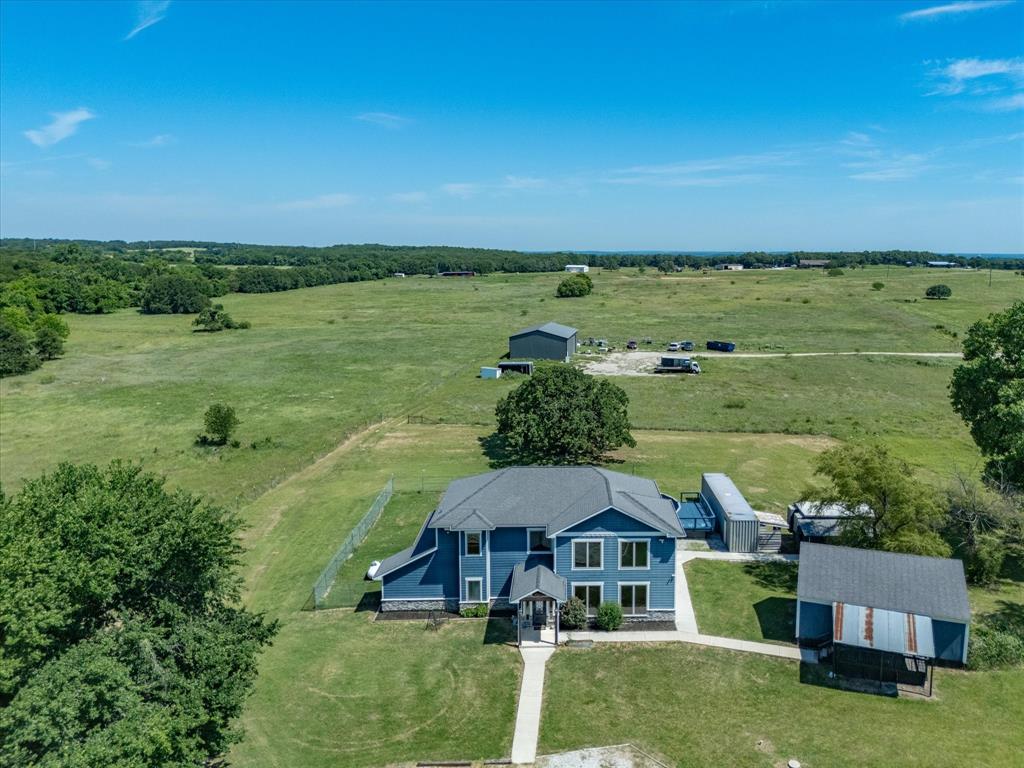 Additional 2.75 acres and shop are available to purchase. Welcome to this private slice of country in the heart of Sunset. Nestled on 5.27 acres, this stunning two-story home offers the perfect blend of comfort, functionality, and peaceful country living. From the moment you walk through the front door, you’re greeted by gorgeous stained concrete floors, soaring open spaces, and a warm, inviting atmosphere designed for gathering and entertaining. The spacious living room is filled with natural light and features built-in cabinetry, electric fireplace, and plenty of room for hosting family & friends. Flowing seamlessly into the kitchen and dining areas, this home was truly made for making memories. The kitchen is a dream with abundant counter and cabinet space, stainless steel appliances, gas cooktop, double ovens, an enormous walk-in pantry, and a dining area large enough for an oversized farmhouse table. The primary suite is a true retreat with private access to the backyard and an en suite that feels like a spa getaway. Enjoy separate sinks, a built-in vanity, a jetted tub for two, a dual-head shower, generous closet space, and even a hidden safe room built directly into the slab. Downstairs also features two separate laundry areas and a pet washing space complete with a doggie door for your four-legged family members. Upstairs, you’ll find 2 spacious bedrooms, each offering their own private bathroom & walk-in closet. Step outside and cool off in the above-ground pool, relax on the deck, or rinse off in the outdoor shower. Just steps away is an additional building featuring two separate rooms, connected by a shared bathroom for guest quarters, a mother-in-law suite, there are endless possibilities. Another concrete building, previously used as an office, also doubles as a storm shelter. The property additionally features a container with electricity for extra storage.