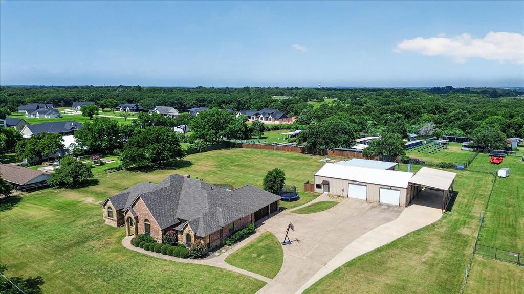 Run your business, store your equipment & enjoy luxury country living—all from one exceptional property. Whether you’re a business owner needing commercial-grade workspace, a family with RVs, boats, trailers & recreational vehicles, or you’re searching for the perfect multigenerational setup, this unrestricted 2-acre property offers opportunities that are nearly impossible to find in today’s market. The centerpiece of the property is the impressive 4,000sf insulated shop, complete with 3-phase power, a dedicated office, climate-controlled workspace-paintbooth & a fully finished 2-bedroom, 1-bath apartment—ideal for operating a home-based business, accommodating extended family, generating rental income, or providing private guest quarters. Outside, you’ll find a 20’x50’ covered RV port with full hookups, capable of accommodating up to a 50ft RV, & abundant room for trailers, work trucks, heavy equipment, boats, recreational vehicles & outdoor toys. The main home offers 4 bedrooms, 3 bathrooms with an open floor plan, vaulted ceilings, built-ins & abundant natural light. The kitchen features granite countertops, a gas cooktop, double ovens, a large island, eat in kitchen & generous storage. A stone fireplace anchors the living room, while the formal dining room is perfect for entertaining.  Additional oversized 3 car garage is attached. The spacious primary includes dual vanities, a soaking tub, separate shower & a WIC. 3 additional bedrooms, a second living room & 2 more bathrooms provide plenty of room for family and guests. Step outside to a covered patio overlooking the sparkling pool with spillover spa, creating the perfect setting for relaxing or entertaining. With its unique combination of unrestricted acreage, commercial-quality shop space, luxury living, multigenerational flexibility, and exceptional RV accommodations, this is a rare opportunity to own a property that works as hard as you do while providing the comfort and lifestyle your family deserves.