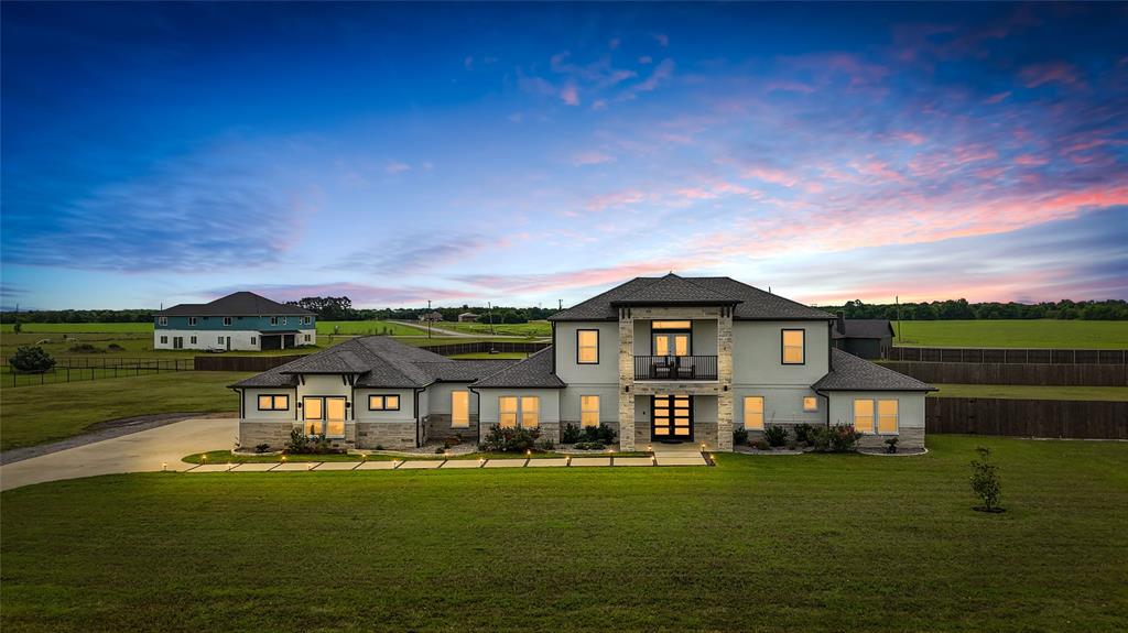 Set on two private acres, this stunning 5,796-square-foot modern Texas Transitional home delivers the rare combination today's discerning buyers are searching for — architectural intention, effortless scale, and the kind of peaceful seclusion that's nearly impossible to find at this level of finish.
From the moment you arrive, the home's clean lines and contemporary Texas Hill Country aesthetic signal something different. Inside, soaring ceilings and walls of windows flood the main living spaces with natural light, framing sweeping views of open fields that shift beautifully with every season. The electric fireplace anchors the great room with warmth and understated elegance — a space equally suited to quiet evenings in and large-scale entertaining.
The kitchen is a true centerpiece: custom cabinetry, striking white quartz countertops, and a marble backsplash come together in a layout designed for both serious cooking and effortless hosting. Every detail here was chosen with longevity and luxury in mind.
Seven generously proportioned bedrooms offer exceptional flexibility — three feature private en-suite baths, making this home as ideal for multigenerational living as it is for hosting guests in genuine comfort. Five full baths throughout the home are finished to match the elevated standard set by the rest of the property, including a spa-inspired primary bath complete with a built-in sound system.
Step outside to a large patio built for gathering, or retreat to the balcony overlooking open fields for a moment of complete stillness. The oversized garage adds practical depth to an already capable property, offering room for vehicles, storage, and more. 
At nearly 5,800 square feet on two acres, this is not simply a large home — it's a deliberately designed one, where every room has purpose and every detail has intention.
Easy Commute to Downtown Dallas!