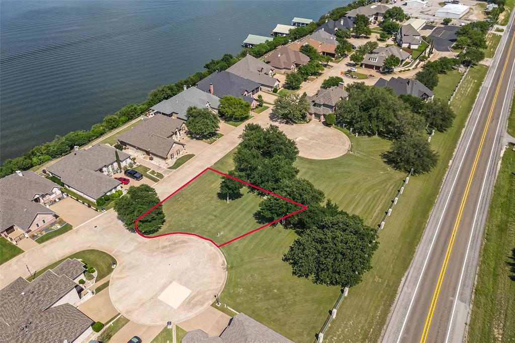 Nestled on a quiet street within the prestigious gated Bluff View on Lake Granbury community, this generously sized 6,534 sq ft (0.15 acre) lot offers one of the most compelling build opportunities on Lake Granbury. Surrounded by mature trees and established custom homes, this parcel provides an exceptional canvas for a single-family custom residence in a neighborhood where quality and curb appeal are protected by thoughtfully crafted deed restrictions. AMUD water, sewer, and natural gas are available, streamlining the path from acquisition to construction. Community amenities include Lake Granbury access, marina slips, and scenic lakeside walking paths — all within a secure gated setting that today's relocation buyers actively seek. Just minutes from Granbury's vibrant Historic Square and approximately one hour from Fort Worth via US-377. Available individually or as a package with 7002 Granite Bluff Ct. Information deemed reliable but not guaranteed. Survey available. Utilities should be independently verified.