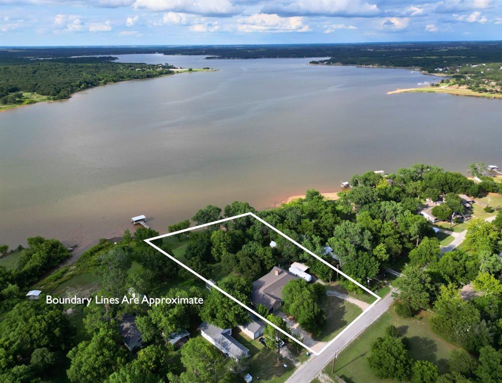 LAKE FRONT HOME! This exceptional waterfront brick home sits on a 1 acre lot at Lake Nocona. Take in peaceful lake views from both the living room or the oversized master bedroom, each with direct access to a large covered patio made for morning coffee and sunset gatherings. With 4 bedrooms and 3 bath, this spacious home is 2200 sq ft and move in ready. The home offers a drive through attached garage for easy access, plus detached covered parking for your boat and a storm shelter for added peace of mind. Outside you’ll find a covered dock with one boat slip and a sturdy waterfront retaining wall. Whether you’re looking for a primary residence with everyday lake living or a fully equipped weekend retreat, this property delivers convenience, comfort, and direct access to Lake Nocona’s recreation. Property has inspection report and new survey.