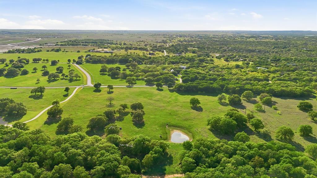 This is a rare opportunity to secure one of Aledo’s most exclusive acreage homesites designed for those who value privacy, space, and a refined, unrestrained way of living. Tucked quietly behind the curve of Kelly Road, River Ranch Road is one of Aledos best-kept secrets - a if you know, you know enclave of only 8 estate-like residences that lead back to the Clear Fork of the Trinity. With limited restrictions in place, this property offers an increasingly rare level of freedom, inviting you to bring horses, livestock, and create a legacy estate tailored entirely to your vision. Set across 13 picturesque AG EXEMPT acres, the land unfolds with a sense of quiet sophistication, featuring mature trees, a serene pond, and a landscape that feels both curated and untouched. A pipe fence lines the front entry, while full perimeter fencing is already in place. With a water well and electric established, the groundwork has been thoughtfully laid for you to begin building without delay. Surrounded by distinguished 10+ acre estates and beautiful custom homes, this property offers a level of privacy and prestige that defines luxury country living. This is where architecture meets land and where intention meets opportunity, providing an extraordinary setting to design and build a home that is both timeless and deeply personal. This property offers seamless access without sacrificing privacy. As Aledo continues to see strong growth and demand for acreage living, opportunities like this remain limited, making this not only a remarkable place to build but also a compelling long-term investment.