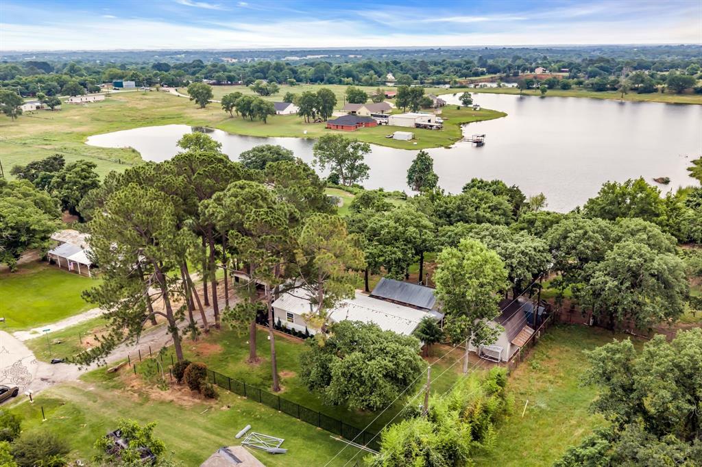 Beautiful lake view Country Setting in Mansfield ISD Welcome to 6000 Tranquility Drive — a beautifully updated home that blends charm, comfort, and country living. Located within highly sought-after Mansfield ISD and zoned for TarverRendon Elementary and Legacy High School, this property offers space and peace. Inside, you’ll find real wood flooring, a metal roof, granite countertops, and a thoughtfully designed kitchen featuring custom cabinets and a large utility room with matching built-ins. This three-bedroom, two-bath home includes two spacious living areas,creating the perfect layout for entertaining or relaxing with family or friends. Sitting on approximately half acre, the property sits under tall pine trees and overlooks a beautiful lake. Enjoy peaceful country living with a covered and screened side porch, an open back porch, a carport, and a large 2-level workshop with electricity for projects and hobbies. Located just outside city limits, this home offers freedom and privacy while remaining close to shopping, dining, and major highways.