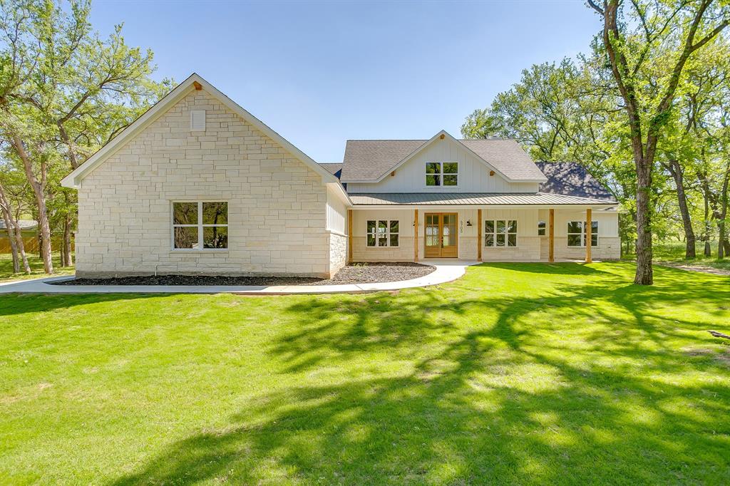 Welcome to 6705 Westover, a beautifully designed custom farmhouse nestled within the highly sought after & amenity rich community of Pecan Plantation in Granbury, TX. From the moment you arrive, the striking white exterior with bold black trim sets the tone for a home that is equal parts stylish, warm & thoughtfully crafted. Inside, gorgeous luxury vinyl plank flooring flows throughout the main living spaces, offering both durability & high end appeal, while the open concept layout creates an inviting atmosphere ideal for both everyday living & entertaining. A dedicated home office provides the perfect work from home setup or flexible space, thoughtfully positioned for privacy. The heart of the home is the kitchen, featuring an abundance of custom cabinetry, a large center island with Carrara quartz countertops, a timeless custom backsplash, & a window above the sink overlooking the backyard that fills the space with natural light. The split bedroom floor plan offers comfort & privacy, with the primary suite serving as a true retreat complete with spa inspired ensuite bath featuring a luxurious soaking tub, separate walk in shower with custom tile work, refined finishes, and an oversized primary closet with custom built ins. Step outside to the covered back patio, an ideal space to relax or entertain while enjoying the peaceful surroundings, with frequent sightings of deer roaming nearby lots adding to the serene setting. Located within the gates of Pecan Plantation, residents enjoy access to two championship golf courses, multiple on site restaurants, a private grocery store & gas station, parks, walking trails, marina & dock access on Lake Granbury, & Brazos River frontage, all contributing to an exceptional lifestyle. 6705 Westover offers the rare opportunity to own a thoughtfully designed home in one of the Metroplex’s most desirable master planned communities, combining quality craftsmanship, natural beauty, & resort style amenities in one exceptional property.
