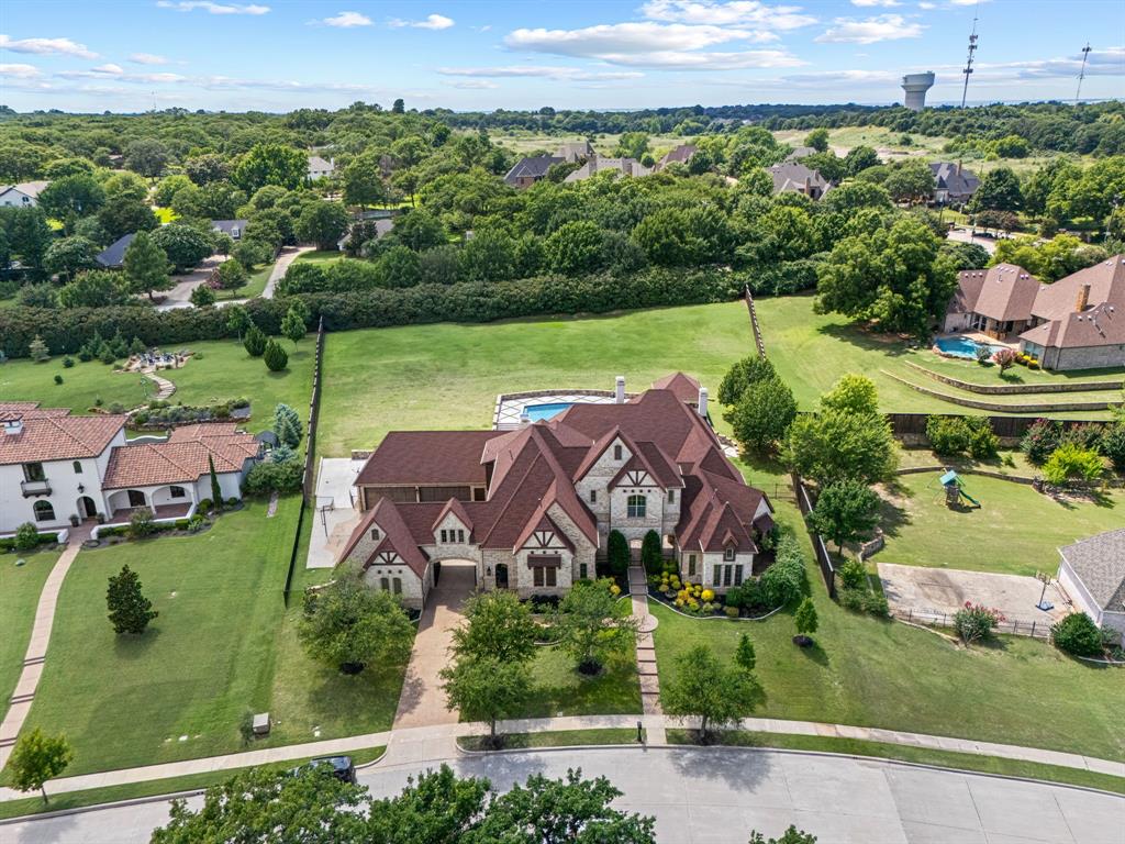 Nestled on 1.26 Acres in The Manors at Waterford, this extensively renovated luxury estate blends timeless architecture, exceptional craftsmanship, and resort inspired living.Offering 5 bedrms,6 full baths,6 car garage,the hm has been thoughtfully transformed w highend finishes,significant improvements thru-out.A private courtyard entry welcomes guests w a custom stone fountain,setting the tone for the elegant interiors beyond.Inside,soaring ceilings,exposed beams,rich hardwood floors,designer lighting,custom millwork create a warm sophisticated atmosphere.The chef’s kitchen serves as the heart of the hm,feat dual islands,custom cabinetry,premium app,built-in refrigeration,wine refrigeration,a walkin pantry,expansive prep,entertaining space.The thoughtfully designed floorplan includes a 1st floor mediarm,executive study w vaulted ceiling,private guest suite,luxurious primary retreat.Private access to the outdoor living areas.The spacious primary suite offers a peaceful sanctuary w beautifully appointed spa inspired bath,oversized custom closet.Upstairs,all bedrms feature ensuite baths,while updated finishes throughout the home provide comfort,functionality.Designed for exceptional indoor-outdoor living,backyd has undergone a remarkable transformation.Enjoy a rebuilt resort style pool w oversized spa,expansive travertine decking,upgraded drainage,retaining walls,custom landscape lighting,automated pool controls,multiple gathering areas,beautifully manicured grounds.Covered outdoor living pavilion feat a fireplace,gathering space,while water features,mature landscaping create a private retreat for entertaining.Add highlights include a porte-cochère,attached and detached garages accommodating 6 vehicles,dedicated pool bath,abundant storage,exceptional attention to detail throughout.Located in one of Keller’s most sought after luxury communities,residents enjoy steps away access to the community fishing pond,walking trails,scenic green space,neighborhood gathering areas