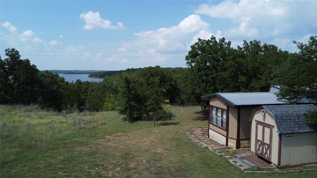 GENERAL DESCRIPTION: This 2.75 acre tract sits on the south side of Lake Amon Carter, offering great views of the lake and surrounding nature. The property acts as almost a 5 acre tract with unincorporated land surrounding it on all but the south side. Alongside the unincorporated land there is over 600 FT. of lake frontage to Lake Amon Carter, only accessible through this property. This 2.75 acres is being cut from a larger tract, offering the buyer the potential to add more acreage. 


LOCATION: Property is just north of the silver lake community. 
~30 Miles to Decatur, TX
~70 Miles to Fort Worth, TX 
~80 Miles to Dallas, TX


WATER: Lake Amon Carter sits directly to the north of the property, which was ranked one of the top-10 places to fish for large-mouth bass according to the Texas Parks and Wildlife Department website. The lake covers more than 1,800 acres and is 50 feet deep at its maximum depth. There is no water skiing on the reservoir side of the lake.


CLIMATE: Sunset, TX, averages 242 sunny days, one inch of snow per year and 33 inches of rain per year. 


UTILITIES: Property is connected to water through City of Bowie Water and has a septic system installed.  
The electric provider is Wise County electric. There are electric poles on the road frontage of the property, but a meter would need to be installed. 


WILDLIFE: White-Tail Deer, Duck, Hogs, Varmints


TERRAIN: The property has a slope from the road frontage towards the lake frontage, with contour starting at 950 FT sloping down to 920 FT. 


IMPROVEMENTS: There is an older manufactured home on the property, which will need TLC before being a full time residency. The home is a 2 bed 2 bath with a front porch alongside the north side of the home. The porch opens up to different decks which offer great views of the lake and surrounding native hardwoods. The is a storage shed just south of the house that currently holds kayaks that the sellers take out on Lake Amon Carter.