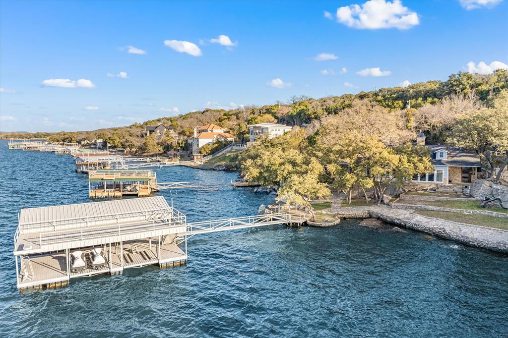 Discover lakefront living at its finest with this exceptional lakefront hillside retreat, offering massive lake views and a timeless design built for lake life. Highlights include a newer two-level dock, on deep water with an oversized slip, a sought-after grassy shoreline with steps into a swim-friendly area, and extensive rock work with natural boulder outcroppings and rock retaining walls. Enjoy shaded outdoor living with an outdoor kitchen, multiple observation decks, and towering trees. This solid-built home was designed for lake life with lake views from open living areas, and features 4 or 5 bedrooms, wood floors, rock fireplace, low-maintenance fiber cement and stone exterior, oversized concrete parking, and a detached double-car carport with storage. High-speed internet available. Priced to sell—don’t miss this lakeside gem with all the sought after features! Income potential as Short Term Rental. View video HavenOnPK. com