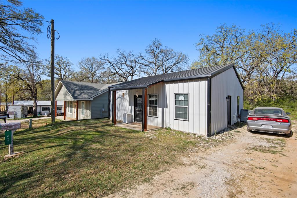 Do you aspire to reside near a lake within walking distance?  Would you love having your own private community amenities, including a park, swimming pool, fishing pier, and direct access to the lake?  This home offers an ideal setting for both an active lifestyle and a tranquil retreat by the beautiful Lake Alvarado!  Experience this barndominium’s charming covered front porch, 10-foot ceilings, water-resistant flooring, and a kitchen equipped with granite countertops.  In addition, there are connections for a full washer and dryer, accompanied by a tankless water heater that serves the entire house, all situated outside city limits.