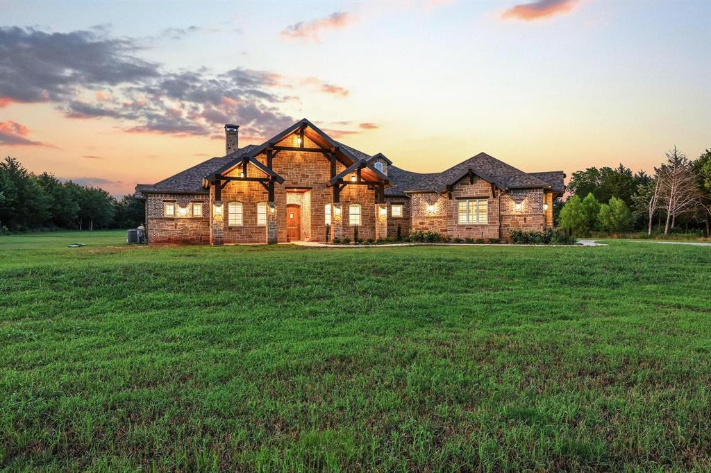 Hidden behind a canopy of mature trees & approached by a winding drive, this extraordinary custom estate offers the rare combination of luxury, privacy, & thoughtful design. From the moment you step inside, the craftsmanship is undeniable. Soaring wood-beamed ceilings, imported Chicago brick accents, rich hardwood floors, & a stunning floor-to-ceiling fireplace create a warm yet sophisticated atmosphere. The open-concept design flows effortlessly. Anchored by expansive quartz surfaces, custom stained cabinetry, & oversized islands, the space is equipped with premium appliances including double ovens, microwave drawer, wine chiller, ice maker, trash compactor, & refrigerator. The primary suite is a true owner's retreat, privately positioned & designed for comfort & convenience. Featuring dual vanity areas, separate water closets, & an impressive walk-through closet & shower, it offers the perfect escape at the end of the day. Designed with both family living & guest privacy in mind, the split-bedroom layout provides spacious secondary suites, each with its own bath. Separate living area tucked between 2 bdrms creates the ideal kids' retreat, guest wing, or flex space. Pocket doors allow this portion of the home to function as its own private suite.  Luxury extends beyond aesthetics. Spray foam insul., tankless WH's, whole-home vacuum, smart-home wiring, built-in sound, oversized garages, private well water, & exceptional storage throughout provide the efficiency & convenience today's buyers expect. Step outside & the property transforms into a private oasis. An expansive patio stretches across the rear of the home  - ample space for entertaining. Beyond lies a spectacular custom pool complete with a grotto, waterfall, slide, fire bowls, & extensive stamped concrete decking. Whether hosting friends, spending time with family, or simply enjoying a quiet evening under the stars, this outdoor space was designed to create unforgettable memories. Additional acreage avail.