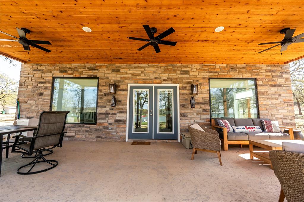 This newly built modern farmhouse offers the perfect blend of contemporary design and rustic charm, sitting lakefront on the beautiful Lake Nocona. Featuring three bedrooms and two bathrooms, this thoughtfully designed home provides both comfort and functionality. The primary bedroom is located downstairs for added convenience, while the two upstairs bedrooms offer ample space, including one with four built in bunk beds, making it ideal for guests or a vacation retreat. The upstairs area remains open to the main living space below, enhancing the home's airy and spacious feel. The kitchen is both stylish and practical, featuring paint grade cabinets with open shelving, butcher block countertops, and a large island bar with a quartz countertop. The island also houses a built-in dishwasher, a two-drawer refrigerator, and an electric plug in for added convenience. A commercial grade Thor appliance package elevates the cooking experience, making this kitchen a dream for any chef. Step outside to enjoy the breathtaking lake views from the covered patio with stamped concrete, perfect for relaxing or entertaining. A lighted sidewalk leads down to the newly built, new covered boat dock, designed to accommodate a 24-foot boat. While the boat lift has yet to be installed, it's ready for customization to suit your needs. The entire yard is equipped with a sprinkler system, utilizing water directly from the lake for efficient irrigation. For pet owners, a fenced in area with turf ensures a safe and low maintenance outdoor space. Additional features include a safe room located under the carport for extra security. This home also comes fully furnished, allowing you to move in and immediately enjoy the lakefront lifestyle. whether you're looking for a full-time residence or a weekend getaway, this modern farmhouse on Lake Nocona is a rare find, combining luxury, convenience, and natural beauty in one exceptional property. OPEN HOUSE.... MAY 22nd!