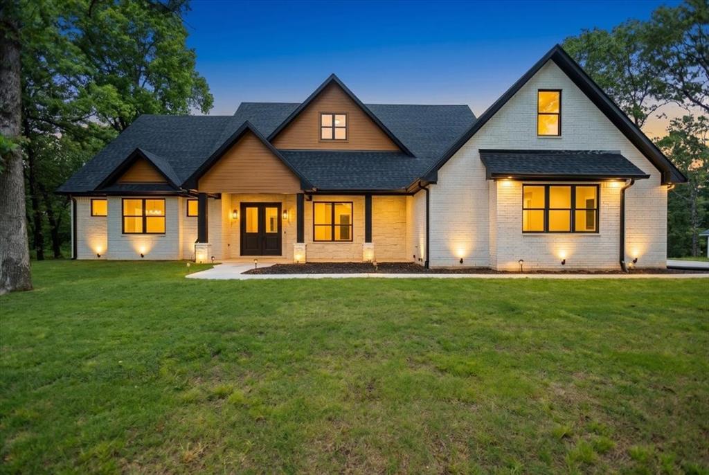 Tucked away in the sought-after Reserve at Tuscany, this exceptional custom home offers a rare blend of luxury craftsmanship and peaceful East Texas living. Surrounded by mature trees and scenic views, the property provides a true sense of retreat. Inside, hand-scraped Red Oak floors, soaring ceilings, and expansive windows create a light-filled, inviting atmosphere. The kitchen is a true showpiece, featuring quartz countertops, a ZLINE 6-burner range, and custom cabinetry with soft-close doors, spice racks, adjustable shelving, and thoughtfully layered accent lighting that elevates the entire space. The privately situated primary suite features a trey ceiling, wall sconces, and a ceiling fan with built-in WiFi. The ensuite bath offers dual sinks, a soaking tub, a spacious walk-in shower, and two walk-in closets, creating a layout that feels both open and beautifully finished. Two secondary bedrooms are connected by a Jack and Jill bath, while the fourth bedroom at the front of the home provides a versatile option for a dedicated office. The utility room is well-equipped with a sink, cabinetry, storage closet, and space for a freezer. Thoughtful details continue throughout, including a stunning built-in display with accent lighting, an expansive pantry, oversized garage, subtle floor lighting, spray foam insulation, 8-foot solid core doors, tankless water heater, high-speed internet, and gas access on the back patio for grilling. The exterior is equally impressive, with beautifully designed lighting and electrical already in place for holiday lights and a future pool. Welcome home, where thoughtful design, quality craftsmanship, and timeless style come together to create something truly special.