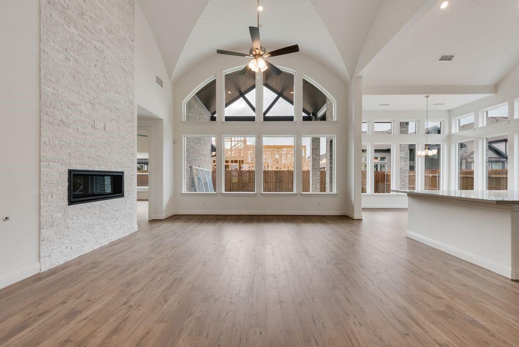 Welcome to this stunning new construction East-facing home that blends modern luxury with thoughtful design in a highly sought-after location. Situated in exceptional Mansfield ISD, all schools are just a short walk or bike ride away. Ideally located between Dallas & Fort Worth, you'll enjoy easy access to shopping, restaurants, and entertainment. This Energy Star Certified home features impressive curb appeal with double front doors and extensive hardwood flooring. Inside, you'll find five spacious bedrooms, a private home office or den, with a downstairs guest suite—perfect for multigenerational living. The open-concept design centers around a groin vaulted family room with a sleek linear fireplace and floor-to-ceiling stonework, flowing seamlessly to a large covered patio with a gas line for BBQ. A full oak staircase with modern wrought iron spindles, eight-foot interior doors, and rocker light switches add to the home’s refined style. The chef’s kitchen boasts Shaker-style cabinetry, Omegastone countertops, a five-burner gas cooktop with commercial-grade vent hood, stainless steel appliances, a built-in trash drawer, and an enlarged island. Downstairs also includes a media room, while upstairs offers a game room and a flexible bonus space or children's retreat. The elegant primary suite features a freestanding tub, dual Marlana vanities with framed mirrors, rectangle sinks and a glass-enclosed tiled shower. With R-38 insulation and a radiant barrier for energy efficiency, this move-in-ready home offers comfort, style, and convenience in a top-tier school district.