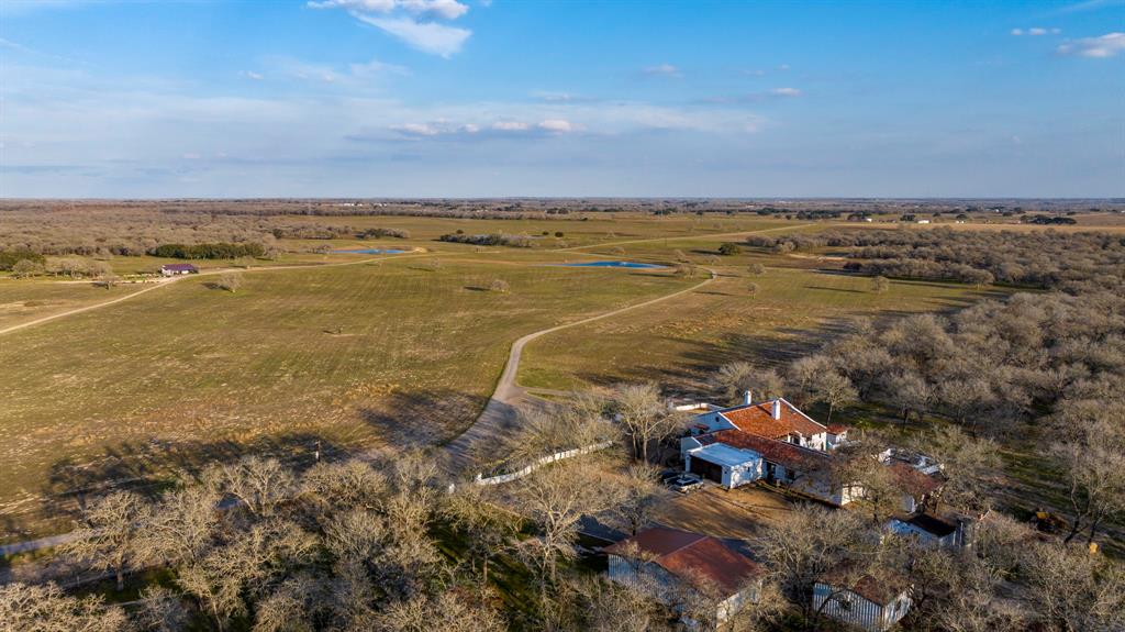 Incredible 1500 Acre High Fenced Ranch in Stockdale, featuring several improvements and many water features. Located 7 miles north of Stockdale, TX, within the Texas Triangle, it is 20 miles south of I-10 or Seguin, 45 miles from San Antonio, 73 minutes to downtown Austin, and 150 miles to Houston. The main house is a 4,400 sqft Spanish-style hacienda with 4 bedrooms, 4.5 baths, a study, living room, sunroom, studio, chef’s kitchen, dining room, and two fireplaces. Features include a heated resort-style pool, spa, and outdoor living and kitchen area. Additional accommodations include a hunting lodge with 1 bedroom and a 3-bed sleeping loft, and a 3-bedroom foreman's quarters. There are two barns (4,500 sqft and 5,000 sqft). Water features include 10 ponds and nine water wells from the Carrizo or Wilcox aquifer. Wildlife includes cattle, whitetail deer, turkey, hogs, ducks, dove, and exotic animals like Axis Deer and Blackbuck Antelope.