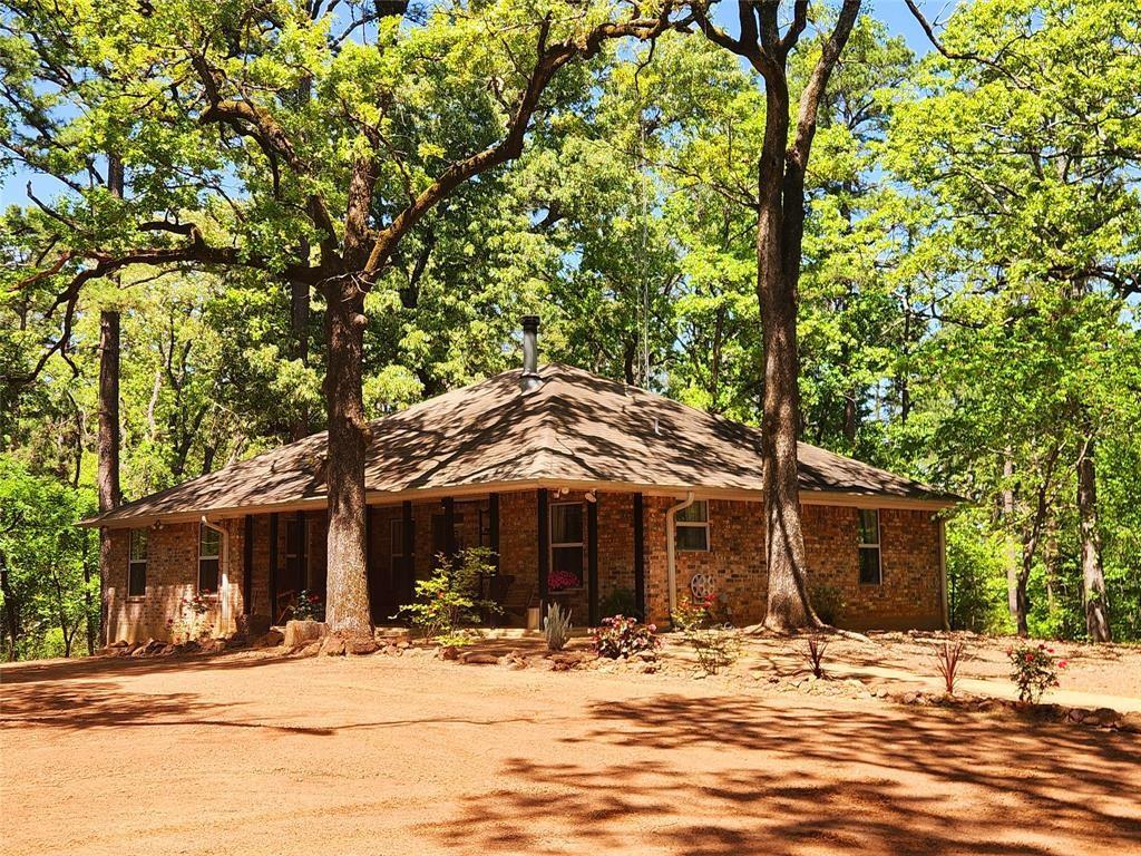 Very private two-bedroom home tucked away on 22 wooded acres with a shop-quarters and other outbuildings. If you love shiplap home interiors, then this home needs to be on the top of your list to visit today! Only 10 miles to Lindale and 13 miles to Van, this home offers that secluded country lifestyle, but with close proximity to stores, doctors, schools, etc. Your choice of either Lindale ISD or Van ISD schools. Both districts provide excellent schools and educational options. Attention hunters, this home and acreage would make for an awesome hunting camp or weekend home too, with excellent whitetail hunting. Current owners have feed plots planted and brush clearings ready for your hunting stands. This hilltop home site has access to a bordering creek, with lots of wildlife visits daily, and gorgeous hardwood trees throughout. Bring the horses or other livestock, Ag project animals, with a fully fenced corral just steps from the front door of the home and the shop building. Awesome steel entrance gate off of the private driveway. The large covered back patio overlooks the hilltop homesite. Oh, and the front covered porch is a great place to sit and watch the sunset, listen to the quiet serenity of nature, and just unwind at the end of your day. You just have to see this home and land to believe it!