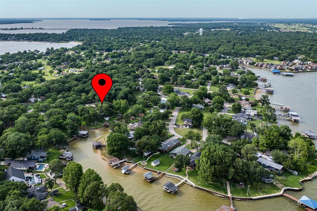 This beautifully updated, charming home is a rare find—situated on two lots in a quiet waterfront channel, making it the only property of its kind in the neighborhood. The home features 3 spacious bedrooms with walk-in closets, 2 bathrooms, and a 2-car garage. Inside, you’ll find a bright, oversized living room with fresh white paint, along with an open-concept kitchen and dining area complete with a breakfast bar—perfect for everyday living and entertaining. Step outside to enjoy peaceful waterfront living. The backyard offers a covered patio and a newly built deck (2022), ideal for relaxing with your morning coffee. The property also includes a new roof installed in December 2021. Additional highlights include a detached guest house that can easily serve as a home office or gym, an above-ground pool with a deck and pergola (built in 2022), a storage building 10x6, boathouse with boat lift, and a private fishing pier. The trampoline and children’s play set will convey with the property. With its unique double-lot setting, versatile spaces, and waterfront amenities, this home truly has everything your family needs—and more.