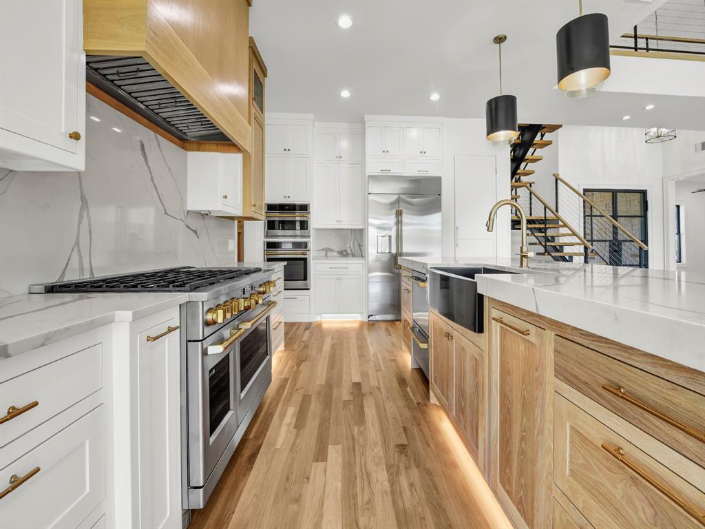 Welcome to 3,341 sq ft of pure sophistication in one of Brock ISD’s most prestigious neighborhoods, Santana Ridge Estates. This stunning 2-story home was crafted with every detail in mind. Enter through steel-framed glass double doors into a grand foyer that sets the tone for what awaits. The open-concept great room is anchored by a 22-foot ceiling and a dramatic floor-to-ceiling stone gas fireplace with floating mantle. Just beyond, a covered patio with wood-burning fireplace offers the perfect retreat for year-round entertaining. The chef-inspired kitchen is a showpiece, boasting quartz countertops with a waterfall backsplash, bold 2.5-inch drop-edge island, GE Café appliances, 48-inch dual-fuel commercial-grade range, built-in oven & microwave, hidden walk-in pantry & champagne bronze accents. Oak hardwoods flow through main living areas, while the mudroom & laundry add warmth with brick flooring & custom built-ins. The primary suite features a spa-like bath with dual shower heads, soaking tub & designer finishes. Two main-level flex rooms add convenience as an office, sunroom or play space. A floating steel-beam staircase with white oak treads & cable railings leads to the upper level, where an expansive loft & catwalk overlook the great room. Upstairs offers a 2nd primary suite, 2 bedrooms joined by a Jack & Jill bath & an added laundry space. A large 2-car garage plus a drive-through single-bay shop with portico provide unmatched versatility. Added features include black-framed windows, tankless water heater, 250-gallon buried propane tank, private well, aerobic septic, ATT fiber & buried utilities. Located just 10 minutes south of Weatherford in Brock ISD, this home embodies the pinnacle of luxury living—where design, comfort & craftsmanship meet the moment you step inside. Call us today to make this home yours!
