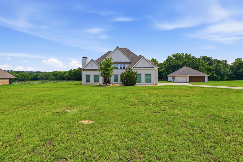 Bring the horses! This exquisite equestrian estate is situated on 2.5 picturesque acres, complete with a premium two-stall stable. Located in the exclusive gated community of Rollins Hills, residents enjoy access to a premier covered arena. Inside, this custom-built masterpiece features 4 bedrooms, 2 spacious living areas, a dedicated media room, and 3.5 baths. Exceptional craftsmanship shines throughout, highlighted by custom cabinetry, elegant triple crown molding, and two cozy wood-burning fireplaces. The gourmet chef’s kitchen is an absolute dream, boasting stainless steel pro-series gas appliances, a double farm sink, and a functional center island with an additional prep sink. Seamlessly blend indoor and outdoor living in the family room, where a large sliding window wall offers sweeping views of your livestock roaming the pasture. Elegant hardwood floors flow through the entry, living areas, and master suite, while durable ceramic tile anchors the kitchen and utility room.  Carpet in upstairs media room, and upstairs bedrooms. Conveniently located near Fort Worth, Azle, Lake Worth, Aledo, and Weatherford—this is a rare find. Schedule your private tour today and fall in love!