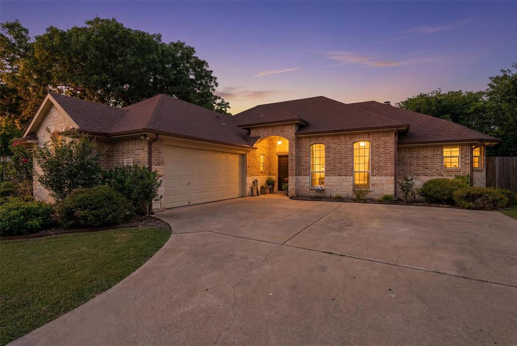 Nestled beneath beautiful mature shade trees in the established Timber Cove community, this 4 bedroom, 2 bathroom home offers 2,016 square feet of comfortable living space on an oversized lot designed for enjoying the outdoors. Built in 2006, the home features an inviting open layout with a spacious living room centered around a cozy wood-burning fireplace, creating the perfect gathering space.

The kitchen and dining areas flow seamlessly into the main living space, while the split-bedroom floor plan provides a private primary suite complete with dual sinks, a soaking tub, separate shower, and generous vanity space. Three additional bedrooms offer flexibility for guests, a home office, or hobbies.

Outside, you'll find your own backyard retreat with a sparkling swimming pool, covered patio, and plenty of yard space to relax, entertain, or play beneath the canopy of mature trees. The oversized lot provides a sense of space that is hard to find while still being conveniently located near everything Granbury has to offer.

As a resident of Timber Cove, you'll also enjoy access to the community boat ramp, making it easy to spend your days on Lake Granbury. Whether you're looking for room to spread out, a backyard built for summer fun, or convenient lake access, this property checks all the boxes.