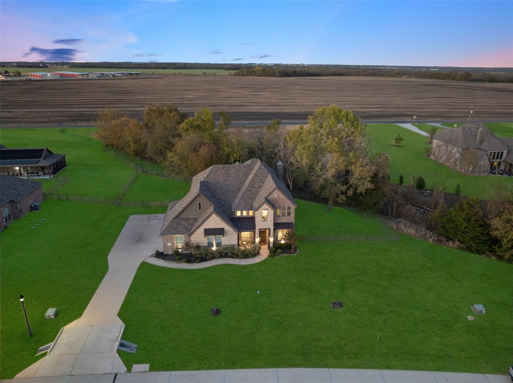 Experience refined country living in this impressive 4,000+ SQFT residence located in the desirable Chapel Creek Farms community of Van Alstyne. Set on over an acre with wide-open views, this home seamlessly blends luxury finishes with a peaceful, spacious setting.
From the moment you arrive, the striking brick and stone façade delivers standout curb appeal. Inside, the home showcases exceptional craftsmanship, including solid wood doors and elegant architectural details throughout. The gourmet kitchen is designed to impress, featuring stainless steel appliances, double ovens, a gas cooktop, a large island with seating, under-cabinet lighting, and beautiful arched openings that add character and warmth.
The open-concept living area creates a welcoming space ideal for both entertaining and everyday living. The primary suite offers a private retreat, complete with a sitting area and scenic views of the surrounding countryside. The ensuite bath is thoughtfully designed with dual vanities, a walk-in shower, and a relaxing corner soaking tub.
Upstairs, you’ll find a spacious game room and a dedicated media room perfect for movie nights, entertaining guests, or creating the ultimate family hangout space.
Additional highlights include decorative iron balusters, a covered patio for outdoor enjoyment, and a built-in gas line ready for grilling. The expansive lot provides endless possibilities, whether you envision adding a workshop, detached garage, or additional outdoor features. An extended driveway offers ample parking and flexibility.
Chapel Creek Farms is known for its quiet atmosphere, generous lot sizes, and strong sense of community ideal for those seeking space without sacrificing convenience. Located just minutes from major employers, including Texas Instruments in Sherman. Easy access to US-75 corridor for shopping in:McKinney, Allen, Frisco, this home offers the perfect balance of accessibility and tranquility.