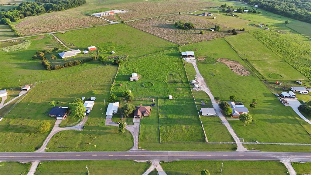 Discover your own private retreat on over four acres of serene Texas countryside. This expansive property is ideal for those seeking space and versatility, featuring a main single-story residence and a fully equipped secondary barndominium. The acreage is thoughtfully designed with cross fencing and two separate barns, making it a fantastic setup for animal lovers, a hobby farm, or those with outdoor projects. The main home offers a welcoming layout designed for comfort and style. At its heart is a cozy wood-burning fireplace complemented by stylish flooring throughout, including wood-look laminate and ceramic tile. Prepare meals in the well-appointed kitchen, which boasts modern cabinetry, ample counter space, and stainless-steel appliances. Enjoy views of your sprawling landscape from the dedicated dining area or move the experience outside to the large covered patio, perfect for relaxing while overlooking the vast backyard. In addition to the main home, the property features a complete 2-bedroom, 1-bath & 1-garage barndominium. This versatile secondary living space includes its own kitchen and living area, providing excellent potential for a rental property, guests or multi-generational living, and even boasts its own separate, fenced backyard for added privacy. The property also includes functional outbuildings for a workshop and storage, alongside modern conveniences like high-speed internet availability and a dedicated laundry area. Parking is a breeze with an attached carport and garage, providing ample covered space. Located in the Alvarado ISD and positioned outside city limits, this property offers the perfect balance of quiet rural living with convenient access to local amenities. This is a great opportunity to own a versatile piece of land with two distinct homes ready for your personal touch.