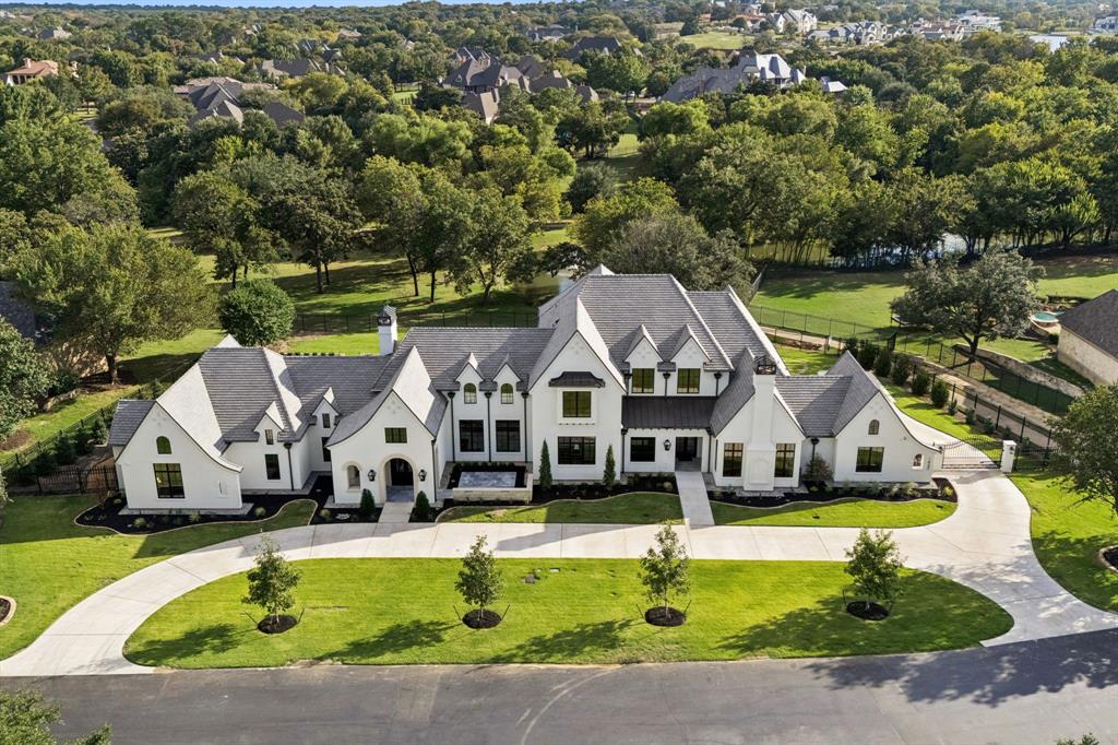 Nestled on .92 acres within the gated community of Glenwyck Farms in Westlake, this extraordinary new construction by Calais Custom Homes took 3 years to build & represents the pinnacle of architectural sophistication and craftsmanship. Spanning 6,750 sqft, this 5 bedroom, 6 bath residence blends natural surroundings with modern design. A DaVinci Slate roof with lightning protection & two custom chimneys highlight the home’s craftsmanship. The home offers an expansive circular drive, automatic gate & 4 car garage with Tesla chargers & epoxy floors in addition to two covered patios with marble pavers, cedar ceilings, remote screens, outdoor kitchen & a sunken firepit that overlook the beautiful grounds. The elegant interior features vaulted & beamed ceilings, wide-plank white oak floors & level 4 wall finishes. The chef’s kitchen is something to envy with Taj Mahal quartzite counters, Wolf & Sub-Zero appliances including a Miele coffee bar, plus a prep kitchen with a 36” Thermador range, refrigerator, dishwasher, Miele steam oven & custom cabinetry with vegetable drawers. The spacious great room features surround sound, a vaulted ceiling & marble fireplace. The primary suite & spa-like primary bath provides that perfect escape with Brizo plumbing fixtures, a steam shower, towel warmer & dual custom His & Hers closets with private laundry. Also located downstairs is a guest suite with stone fireplace, a media & gameroom with quartzite bar, theater-grade projector & Dolby Atmos system, wine room & private office. 3 additional bedrooms with two living areas & balcony are located upstairs. The home is fully integrated with Savant Smart Home controls for Lutron lighting, audio, security cameras, climate systems & Trane HVAC systems & the windows are pre-wired for automatic shades. Residents in Glenwyck Farms enjoy ponds, walking trails & a 13.5 acre park along with top-rated schools including Westlake Academy & Carroll ISD.