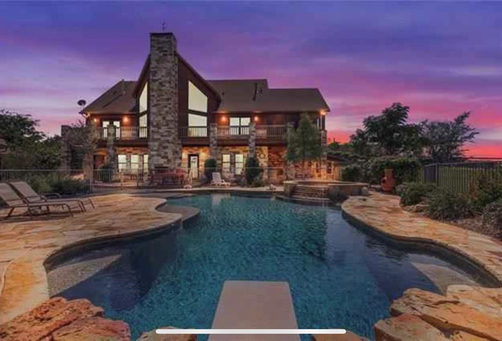 Spectacular 3 story custom waterfront home on Lake Granbury. This fabulous home offers a large living area with a floor to ceiling stone fireplace,  vaulted cedar beamed ceiling, spacious bedrooms, built-in bunk beds beautiful kitchen with a breakfast bar and island, a utility room with lots of storage, a large enclosed porch and two open porch areas with great views. Many amenities are highlighted by a large outdoor living area with a fence-in saltwater pool with attached spa, an outdoor fireplace, a lighted double deck boat dock with lift plus an amazing 2 story guest home with two bedrooms, a kitchen, fireplace and a covered patio. This quality property is an entertainment mecca. Some seller finance, substantial down required.