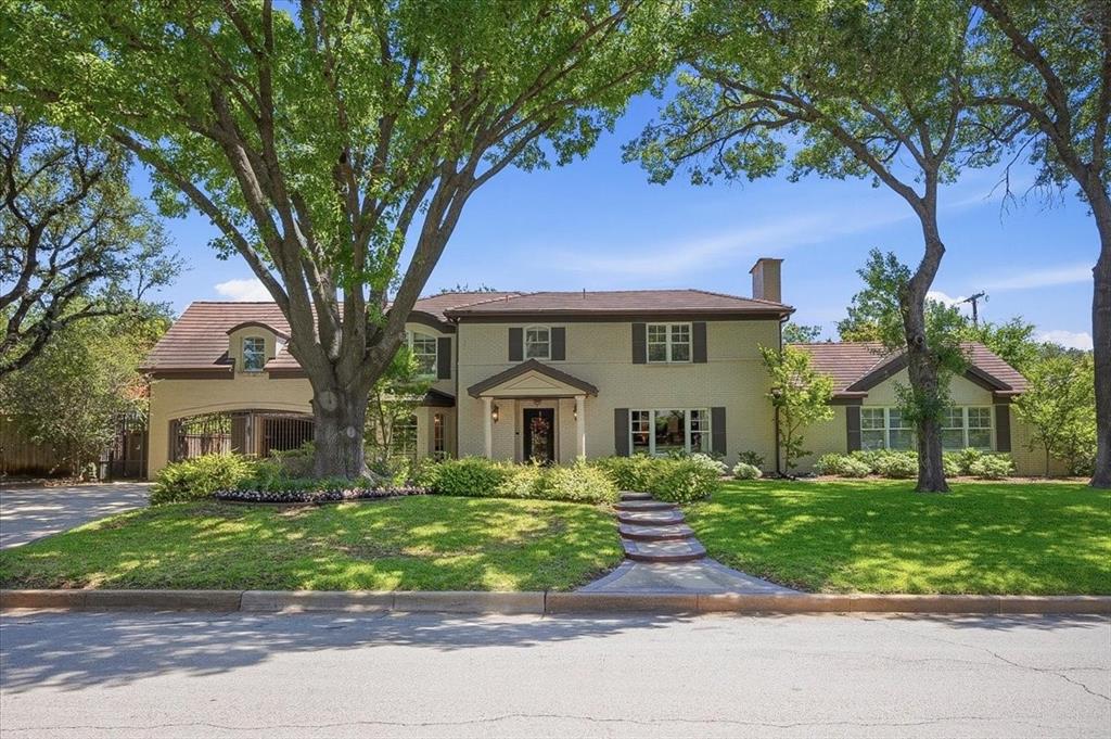 Set in one of Fort Worth’s most desirable pockets, just moments from River Crest Country Club and the Camp Bowie bricks, this home pairs an exceptional location with a thoughtfully maintained, timeless design. Offering 5 bedrooms and 5.1 baths, the layout is both generous and flexible, with two primary suites—one on the main level and a second upstairs—creating options for a variety of living arrangements. A spacious office and dedicated wine room add to the home’s functionality, while multiple living areas provide a comfortable flow for both everyday use and entertaining.
The kitchen is well-equipped with stainless appliances, ample workspace, and a functional island, opening easily to the main living areas. Natural light fills the home, enhanced by updated windows, wood flooring, and custom built-ins that bring warmth and character throughout.
The main-level primary suite features an updated bath and a custom closet, while upstairs includes three additional en suite bedrooms, the second primary suite, and a flexible bonus space suited for a secondary office, playroom, or lounge. Outdoors, a covered living area with travertine flooring, vaulted ceilings, a stone fireplace, and a built-in grill extends the living space and creates an inviting setting for gathering or unwinding. A great opportunity to own a well-positioned home with scale, flexibility, and lasting appeal in a premier location.