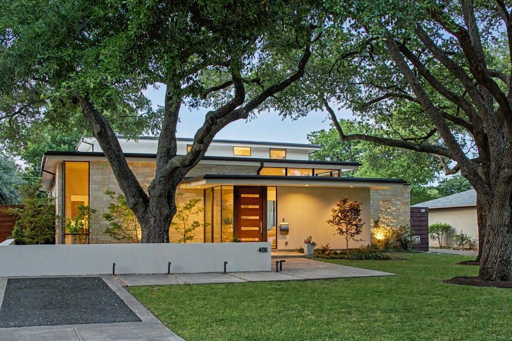 This Midway Hollow residence earned an AIA award for its design—and standing at its center, surrounded by glass on three sides, it’s easy to see why.
The home was conceived around the idea of spatial continuity. Each main living area—living, dining, and kitchen—opens to a central courtyard, complete with a fireplace and covered patio. With three distinct landscaped environments, the quarter-acre lot feels like a natural extension of the home itself.
Inside, terrazzo floors run throughout the first level, while museum-finished walls and precision art lighting reflect a home designed with the collector in mind. The living room is anchored by a full-height limestone fireplace and flows seamlessly into a well-proportioned dining space suited for both entertaining and everyday living.
The kitchen is defined by an iridescent shell mosaic tile backsplash—unexpected and striking. A gas cooktop with commercial-grade vent hood, double convection ovens, and ample built-in storage ensure functionality, while the white quartz island adds a social focal point.
The primary suite, located on the main floor, offers a sense of seclusion with its own courtyard views. Its spacious bath features fine millwork, two water closets and a soaking tub, with thoughtful attention to every detail.
Upstairs, two guest suites and a flexible living area expand the home’s footprint and provide versatility for a range of needs.
The property truly comes alive at dusk, when light spills through the glass walls beneath a painted sky and tree canopy, turning everyday moments into something remarkable.
Located at 4011 Highgrove Drive, the home offers the quiet charm of Midway Hollow with the convenience of nearby Central Market. Premier dining and shopping destinations—including Inwood Village, Preston Center, and the Park Cities—are all within easy reach.