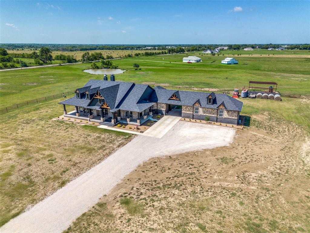 Discover this exceptional custom-built home that seamlessly blends comfort with sophistication. This three-bedroom, three-bathroom residence showcases premium materials throughout, including stunning granite countertops and rich hardwood flooring that flows beautifully under soaring vaulted ceilings.The heart of the home features an open floor plan connecting the eat-in kitchen with its convenient gas stove to spacious living areas. Three charming fireplaces create perfect gathering spots for cozy evenings. The thoughtful layout includes a dedicated office space and an additional living room that doubles as a versatile game room. The primary bedroom boasts a luxurious en suite bathroom, while two additional bedrooms provide flexible options for family or guests. Quality craftsmanship is evident in every detail of this well-constructed home. Outside, you'll appreciate the generous lot size that offers plenty of space for outdoor activities and future possibilities. The impressive four-car garage provides exceptional parking and storage solutions, making this property ideal for car enthusiasts or those needing extra space. There is also an additional 5 acres adjacent to this property available to purchase. See MLS #21056651