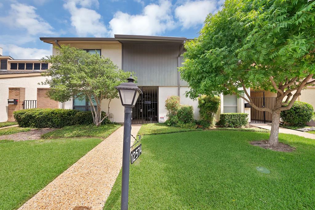 This unique townhouse in the Chimney Hill subdivision offers a tranquil living experience with an emphasis on peacefulness and community. The interior features a combination of ceramic tile, wood, and laminate flooring throughout its two levels. The heart of the home is an open living area centered around a masonry wood-burning fireplace, complemented by vaulted ceilings and decorative wood beams that create an airy and expansive feel. A separate dining area and a galley-style kitchen, complete with built-in cabinetry, a pantry, and a suite of white appliances, make the main floor both functional and inviting. Upstairs, the spacious primary suite serves as a true retreat, featuring its own private fireplace, a dedicated sitting area, and a large walk-in closet. The attached ensuite bathroom is well-appointed with dual sinks, a jetted tub, and a separate shower. Additional interior highlights include a bonus room with built-ins and a dedicated laundry area for convenience. The outdoor area is equally serene, with a private courtyard perfect for relaxation. This property combines unique architectural character with the convenience of a well-maintained home.