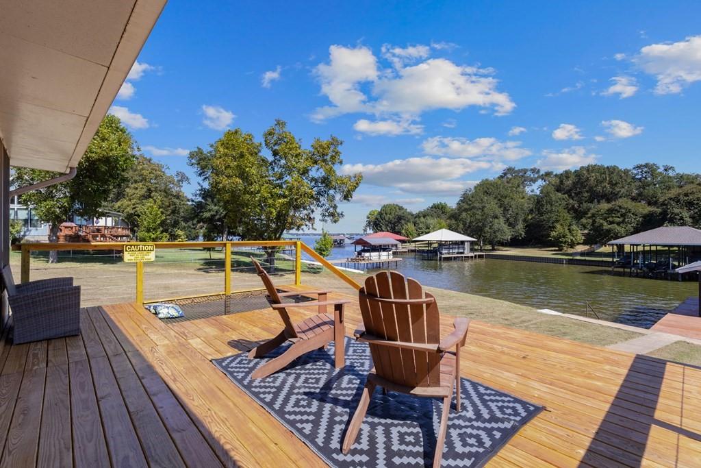Discover a remarkable opportunity at Cedar Creek Lake, nestled in a coveted location near Gun Barrel City and all essential amenities. This home boasts breathtaking waterfront views from almost every window, bathing the interior in abundant natural light. Situated on an expansive lot and a half, it features 54 feet of water frontage, providing ample space for entertaining. Positioned perfectly on a large cove just three houses from the point, this home enjoys protection from harsh waves, making it an ideal spot for kayaking, paddle boarding, and serene boating. The calm waters offer a safe and easy launch for your boat, with easy access to open water just around the corner. The perfect water position. This three-bedroom, two-bathroom residence spans over 1,600 square feet and presents a superb open-concept floor plan. The spacious living area, complete with a fireplace, seamlessly integrates with the dining room and kitchen, creating a fantastic space for entertaining and