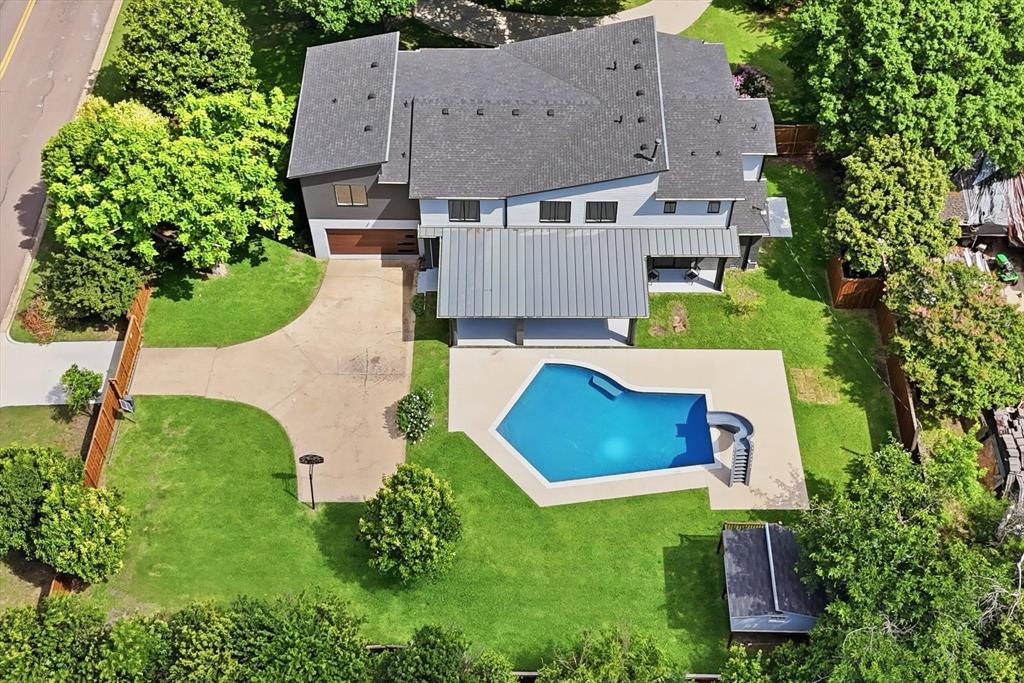 Located on a rare .57-acre lot in highly sought-after Northwood Hills, this extensively remodeled two-story mid-century modern home offers exceptional indoor & outdoor living. Renovated in 2023, major updates include all new electrical wiring, plumbing, HVAC systems, 2 tankless water heaters & a new roof. The open living & kitchen areas are designed to maximize views of the expansive backyard through large sliding glass doors. The kitchen features quartzite countertops, Wolf appliances, a built-in Sub-Zero refrigerator, Cove dishwasher, crushed ice maker, beverage refrigerator, filtered prep sink, Miele built-in coffee system & microwave. A large walk-in pantry located between the kitchen and garage includes a second dishwasher, sink & Sub-Zero wine refrigerator. The private backyard is a standout feature, offering a recently updated quartz-finish pool, multiple patios, large lawn areas, mature trees, a custom treehouse, waterslide, and pool bath, providing ample space for recreation and entertaining. The 1st floor primary suite is privately situated & includes a spacious bath, large WI closet with dedicated laundry & access to a private patio. Upstairs are 4 additional bedrooms, all with WI closets, including 2 with en-suite baths, plus a 2nd full laundry room. Additional living spaces provide flexibility for everyday living, working from home, or hosting guests. Large windows bring in abundant natural light & create a strong connection to the outdoor spaces. The floor plan offers privacy for the primary suite while maintaining open gathering areas ideal for family living & entertaining. The oversized lot provides room for play, gardening and pets, while still maintaining plenty of green space around the pool. Located within Richardson ISD, this home combines modern updates, functional living spaces & one of the largest lots available in Northwood Hills, offering a rare opportunity to enjoy both space & convenience in one of Dallas' most established neighborhoods.