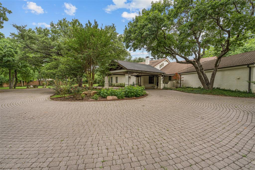 4812 Williams Road blends the warmth of a Southwestern hacienda with the scale and amenities of a private resort, all set across nearly 5 gated acres in Benbrook. Enter over a covered bridge to discover a sprawling estate designed for both everyday living and unforgettable entertaining, featuring 5 bedrooms, multiple living areas, a game room, and a chef’s kitchen outfitted with commercial-grade appliances and extensive custom cabinetry.
The outdoor experience is truly exceptional, centered around a pool and expansive covered patio complete with an outdoor fireplace and fully equipped pool house featuring a kitchenette, full bath, and its own fireplace. Additional highlights include a separate guest house with full kitchen and living area, workshop, tree house, baseball backstop, fire pit, and beautifully treed grounds irrigated by a private water well. The property features a total of five fireplaces creating warm and inviting gathering spaces throughout the estate. With multiple entertaining areas and a setting that feels worlds away while remaining central to Fort Worth, 4812 Williams Road offers a truly one-of-a-kind lifestyle opportunity.