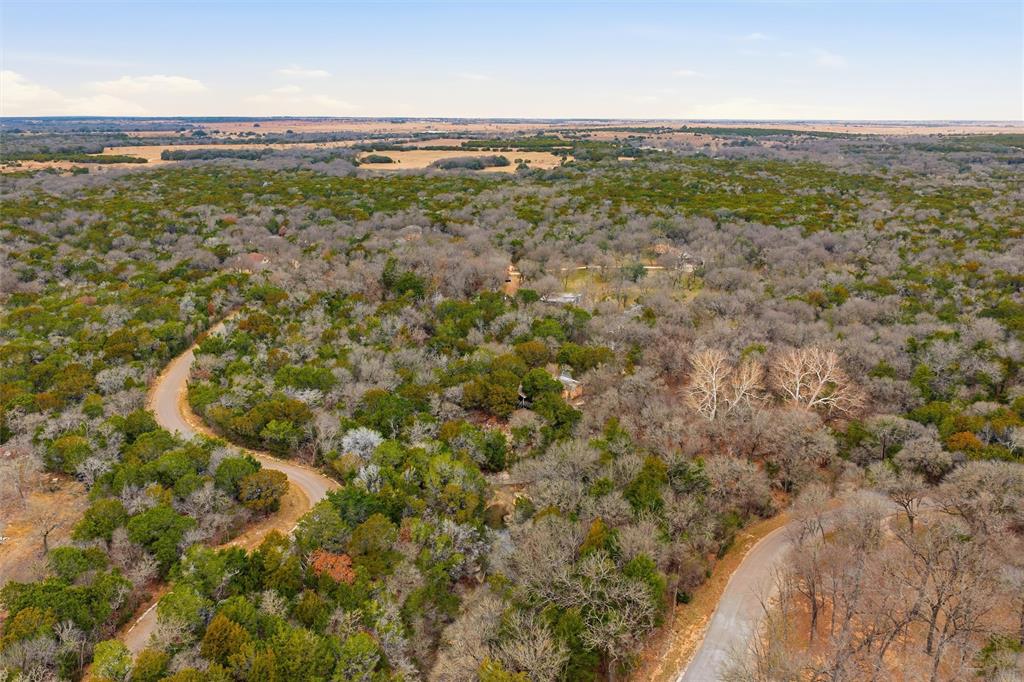 Discover the rare opportunity to own over 11 beautifully wooded acres in the highly sought-after China Spring ISD—an exceptional setting for those seeking space, privacy, and endless potential. This versatile property offers the perfect balance of immediate enjoyment and long-term vision, whether you plan to build your dream home, need a weekend escape, or want to establish a private hunting retreat. The land is rich with natural beauty - you'll be in awe of the rock outcroppings, scenic Rock Springs Creek, rolling terrain, and abundant wildlife.  An existing 840-square-foot dwelling with a full kitchen, bathroom, and garage provides a comfortable base for everyday living, weekend stays, or use during future construction.  Electricity is already in place for 4 RV hookups, with a water and septic sewer connection too!  From quiet mornings surrounded by nature to evenings spent watching wildlife move through the trees, this acreage invites you to slow down and enjoy the land.  Come experience the feeling of being worlds away, while enjoying the convenience of nearby China Spring and Valley Mills, and a short commute to Waco. This property presents a truly special opportunity to create something uniquely your own—where your vision can take shape amid the beauty of the Texas countryside.