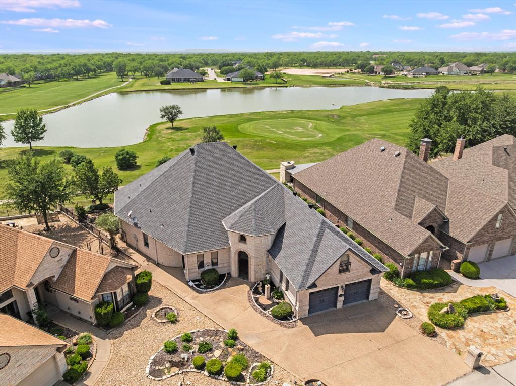 Nestled on the Nutcracker Golf Course in the gated community of Pecan Plantation, this low-maintenance gem sits on a quiet cul-de-sac & makes an unforgettable first impression. The striking tower-style entrance, light stone & brick exterior & bold dark garage doors create standout curb appeal that sets the tone for everything inside. Step through the rich wood front door into soaring ceilings & an elegant staircase that draws your eye upward — leading to a versatile unfinished attic space ready to become your bonus room, studio, or storage haven. Crown molding graces the living areas, where a dramatic floor-to-ceiling stone fireplace anchors the room & large picture windows frame sweeping views of the golf course: a view you'll never tire of. The spacious kitchen is a true entertainer's dream, featuring granite countertops, a center island, breakfast bar seating, stainless appliances, a dedicated dining area & more storage than you'll know what to do with. A half bath serves guests & oversized laundry room with even more storage to keep life organized. Retreat to the expansive primary suite, complete with an ensuite featuring: dual sinks, vanity seating, a walk-in shower, a jetted tub & a generous walk-in closet. A second large bedroom & a full bath provides comfortable space for guests, while a dedicated office gives you the quiet workspace you deserve. Out back, enjoy your covered porch spanning nearly half the length of the home — perfect for morning coffee or evening sunsets over the course. The fully fenced yard features a low-maintenance rock landscape with raised garden beds for your green thumb moments. A two-car garage plus a dedicated golf cart garage complete this thoughtfully designed home. As a resident of Pecan Plantation, you'll enjoy 24-7 gated security and an unparalleled lifestyle: golf, multiple swimming pools, tennis & pickleball courts, fine dining, a pharmacy, bank, car wash & even a full-service grocery store, all within the gates.