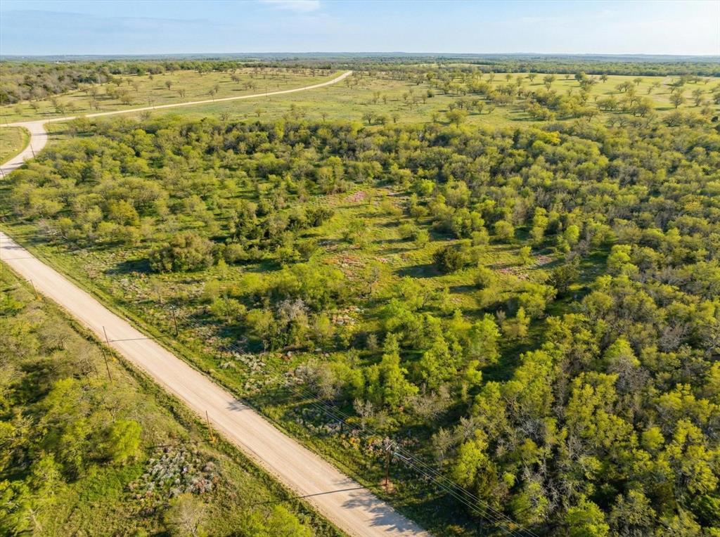 Beautiful 8.079-acre tract located in the scenic, gated community of Paradise Oaks Ranch. This ag-exempt property offers a peaceful country setting with mature hardwood trees, natural privacy, and multiple ideal build sites for your custom home or barndominium. The gently usable terrain provides room for horses and livestock while maintaining the open ranch character the community is designed to preserve. Paradise Oaks Ranch is a thoughtfully planned ranch subdivision centered around agricultural use and long-term land stewardship. Each tract supports one primary residence and participates in a grazing association that helps maintain the agricultural valuation. There is no minimum square footage requirement for the home, and barndominiums are allowed, providing flexibility in design while maintaining community standards. Owners may fence a designated homestead area surrounding the residence and improvements — ideal for a house yard, barn, arena, pens, and turnouts — while the remaining acreage stays open pasture to preserve the ranch setting and sustain the ag exemption. This balanced approach allows you to comfortably keep horses and build functional facilities without concern of surrounding overdevelopment, commercial activity, or dense subdivision. The design protects property values, supports lower taxes, and maintains the wide-open landscape the community was created to preserve. Enjoy quiet acreage living among well-kept ranch properties in a secure gated setting. A great opportunity to build now or hold as a long-term investment in a protected ranch community. Graford ISD.