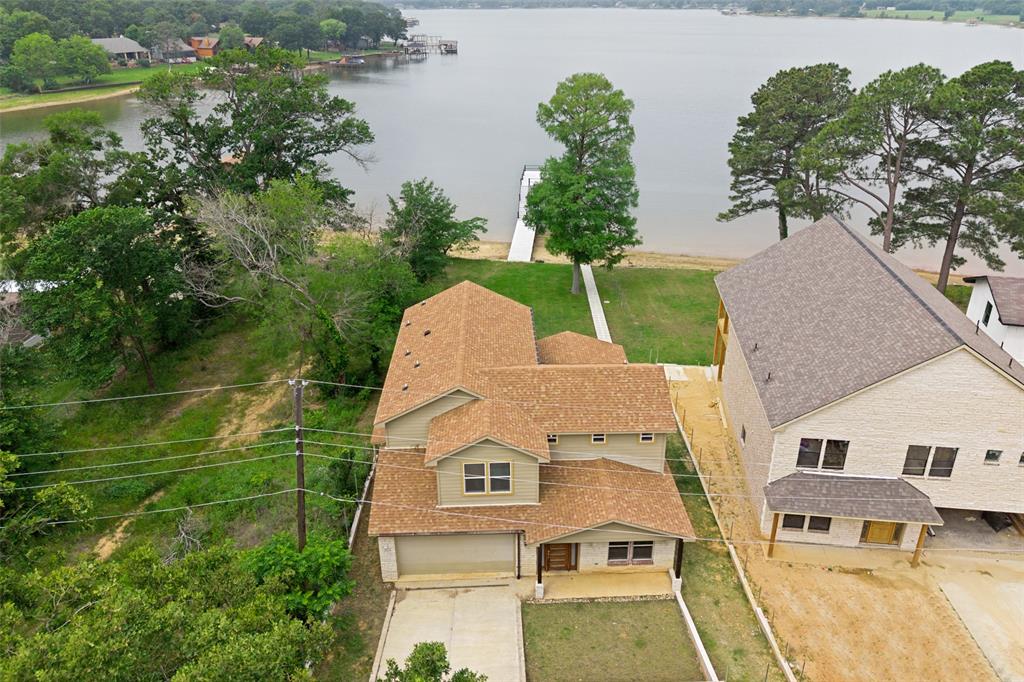 Experience luxury lakefront living with this exceptional new construction home on Cedar Creek Lake, perfectly positioned on deep water with expansive, unobstructed views. Designed for both comfort and entertaining, this residence offers refined finishes and thoughtful upgrades throughout. This 3-bedroom home includes a dedicated office that can serve as a 4th bedroom, providing flexible living space. The open-concept floor plan seamlessly connects the living, dining, and kitchen areas, all oriented to maximize breathtaking lake views. The kitchen is appointed with granite countertops, a large center island with seating, a walk-in pantry, and soft-close cabinetry, blending style with functionality. The main living area features vaulted ceilings, a wood-burning fireplace with a stone surround, and durable porcelain wood-look tile flooring throughout the main level. The spacious primary suite includes dual vanities, a garden tub, and a separate walk-in shower, offering a private retreat with modern comfort. 
Additional features include a 20’ x 30’ garage, a large backyard, and a full-width covered patio ideal for outdoor entertaining and lakeside relaxation. 
Recent improvements enhance long-term peace of mind, including a new 2025 boathouse with composite decking, a boat slip, and an upper-level party deck. The property also includes a new septic system, and the home has been professionally treated for termites to prevent future concerns. A new fence and mailbox will be installed. Move-in ready and designed for effortless lake living, this home delivers modern luxury on one of Texas’ most desirable waterfront settings. Schedule a tour today!