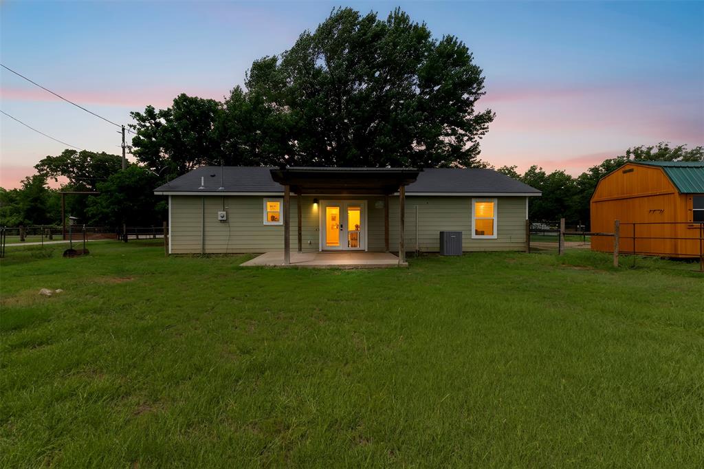 Welcome to country living in Grandview! Situated on .65 acres with beautiful shade trees, this updated 2-bedroom, 2-bath home offers the perfect blend of comfort, charm, and functionality. Inside, you’ll find an inviting open layout with luxury vinyl plank flooring, granite countertops, stainless steel appliances, and plenty of kitchen storage. The bedrooms are comfortably sized, with a convenient laundry area and updated guest bath. Step outside to enjoy the covered front porch, spacious yard, and two outbuildings—ideal for storage, hobbies, or small livestock. Located in Grandview ISD, this is a wonderful opportunity to enjoy the ease of small-town living. Washer, dryer, and refrigerator convey.