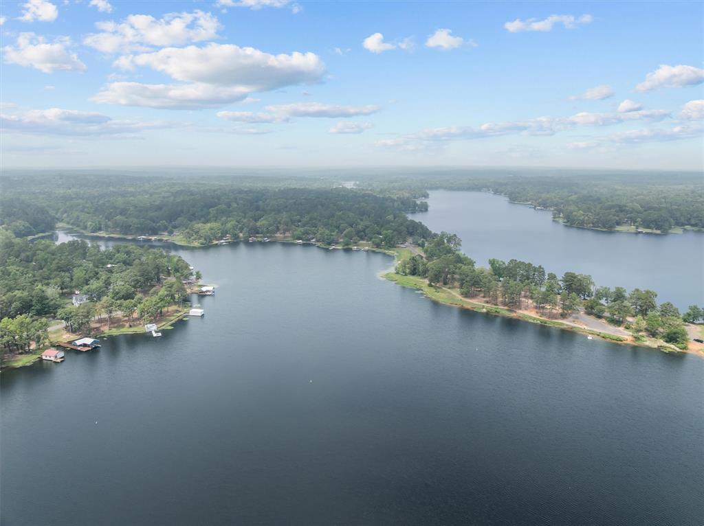Tucked away in the peaceful setting of Lake Hawkins, this property offers a rare opportunity to enjoy true East Texas charm with endless potential. Positioned in the only swimming cove on the lake and just steps from Taste of Italy, the location alone sets this property apart—perfect for those who want both relaxation and a touch of local charm right at their doorstep. The home features a spacious 2-bedroom layout with a unique two-story loft complete with bunk beds and room for many more—ideal for hosting family, guests, or creating a fun retreat-style sleeping space. With 2 full baths and 1 half bath, there’s plenty of flexibility and comfort for gatherings or weekend getaways. Surrounded by mature trees and the natural beauty of the area, the property offers a quiet escape from the city while still being an easy drive from the Dallas metroplex. The expansive outdoor space invites you to relax, entertain, and fully embrace lake life. The home does need some TLC, making it a great opportunity for buyers looking to personalize, invest, or create their own lakefront escape in a highly desirable setting. Whether you’re envisioning a weekend retreat, short-term rental, or a place to make your own, this property delivers on location, character, and potential.