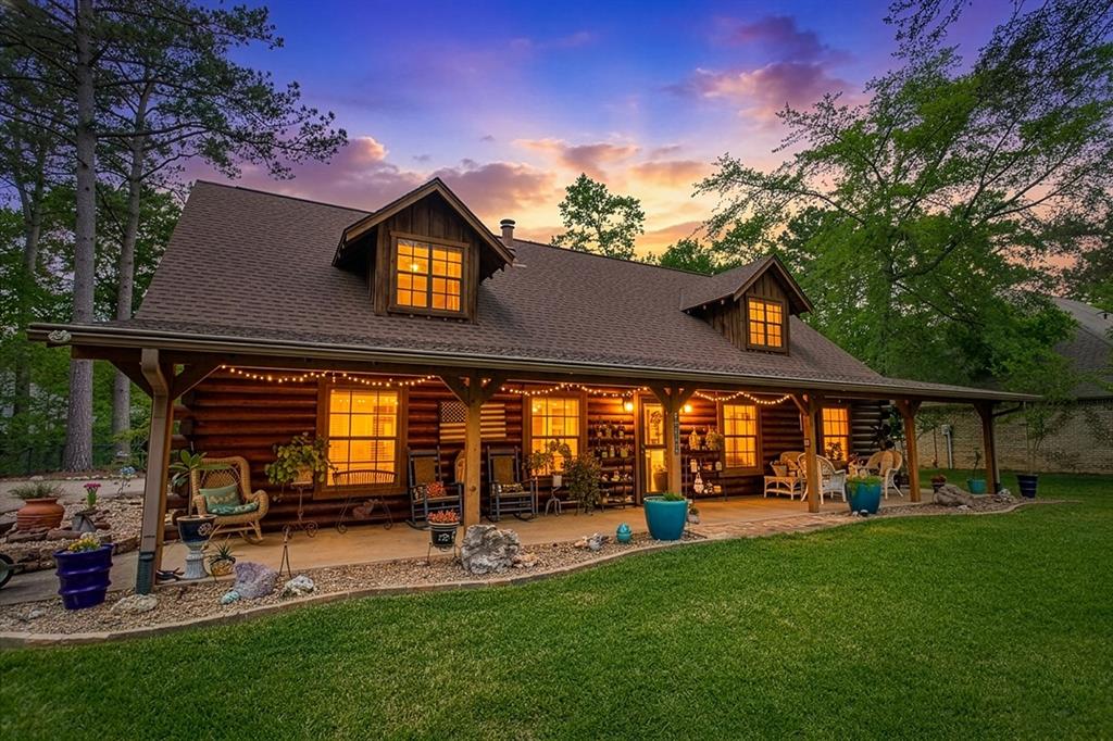 This stunning Satterwhite log home offers 2,550 square feet of timeless character and inviting comfort. Designed as a 1.5-story residence, the home features 4 bedrooms and 3 full bathrooms, blending rustic charm with thoughtful functionality. A full-length covered front porch welcomes you and provides an ideal space to relax and take in the peaceful surroundings. Inside, wood flooring and a dramatic vaulted beaded-board ceiling create an immediate sense of warmth and craftsmanship. The spacious living area is anchored by a cozy wood-burning stove and enhanced with built-in bookshelves, making it perfect for both entertaining and everyday living. The kitchen is well-appointed with a custom island, abundant cabinetry, and an adjoining dining area designed for gatherings. The main level includes a generously sized laundry room, ample storage throughout, and a large primary suite for convenient single-level living. The primary bathroom features dual vanities, a walk-in closet, and a dedicated dressing area. A second bedroom or study and a full bathroom complete the downstairs layout. Upstairs, two additional bedrooms are joined by a versatile game room or bonus space, offering flexibility for guests, hobbies, or recreation. The upstairs full bathroom provides extensive storage to keep everything organized. Outside, the fenced backyard is beautifully landscaped and complements the natural appeal of the log construction. An attached carport offers substantial attic storage, while additional amenities include a full yard sprinkler system, rain gutters, a circular driveway, and a separate storage shed. This exceptional home combines classic log-home charm with modern convenience in a truly inviting setting. Hideaway residents enjoy a resort-style living with amenities including security, 3 scenic lakes, 27-hole golf course, tennis and pickleball courts, an Olympic-sized pool, multiply parks, nature trails, a beach area, and a dog park. Hideaway is in Lindale ISD.