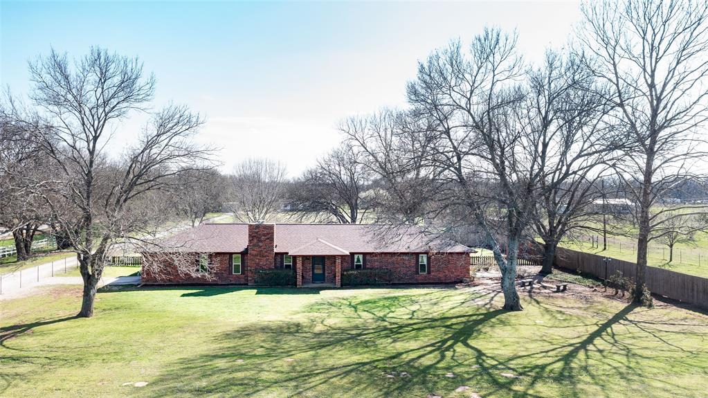 Enjoy peaceful country living on 2.98 acres beneath mature trees in this 3-bedroom, 2-bath home offering privacy, comfort, and timeless appeal. From the moment you arrive, you’ll notice inviting curb appeal, a shaded front yard, and a thoughtfully designed layout that makes everyday living feel effortless. New roof in 2025!
Inside, natural light fills the bright spaces, creating an airy and inviting feel throughout the home. The gourmet kitchen is a true centerpiece, featuring granite countertops, a spacious island with a built-in beverage fridge, and ample cabinetry with great prep space. It flows seamlessly into the dining and living areas—perfect for entertaining or simply enjoying time at home.
A cozy wood-burning fireplace anchors the living space, while a versatile bonus room provides endless possibilities as a game room, fitness area, playroom, or second living space. A separate office area offers a dedicated spot for work or study. The primary suite offers a peaceful retreat with abundant natural light, and beautiful flooring throughout adds warmth and a cohesive feel.
Step outside to discover private courtyard spaces, ideal for relaxing or entertaining, with room for seating, a fire pit, or garden features. The property also features excellent storage and workspace, including two large shops, a 110v storage barn for an RV, boat, or camper, and a separate insulated 220v workshop—perfect for hobbies or a small business, with space for projects, tools, and equipment.
If you’re looking for space, versatility, and a serene setting, this property delivers. Conveniently located in Wise County—just 20 minutes from Lake Bridgeport and offering a short commute to DFW Airport, Denton, or Fort Worth—you’ll enjoy peaceful living with easy access to shopping, dining, and local amenities.
Come experience it for yourself and see why this property feels like your own private escape—make this yours today with your finishing touches and make it truly your own retreat!
