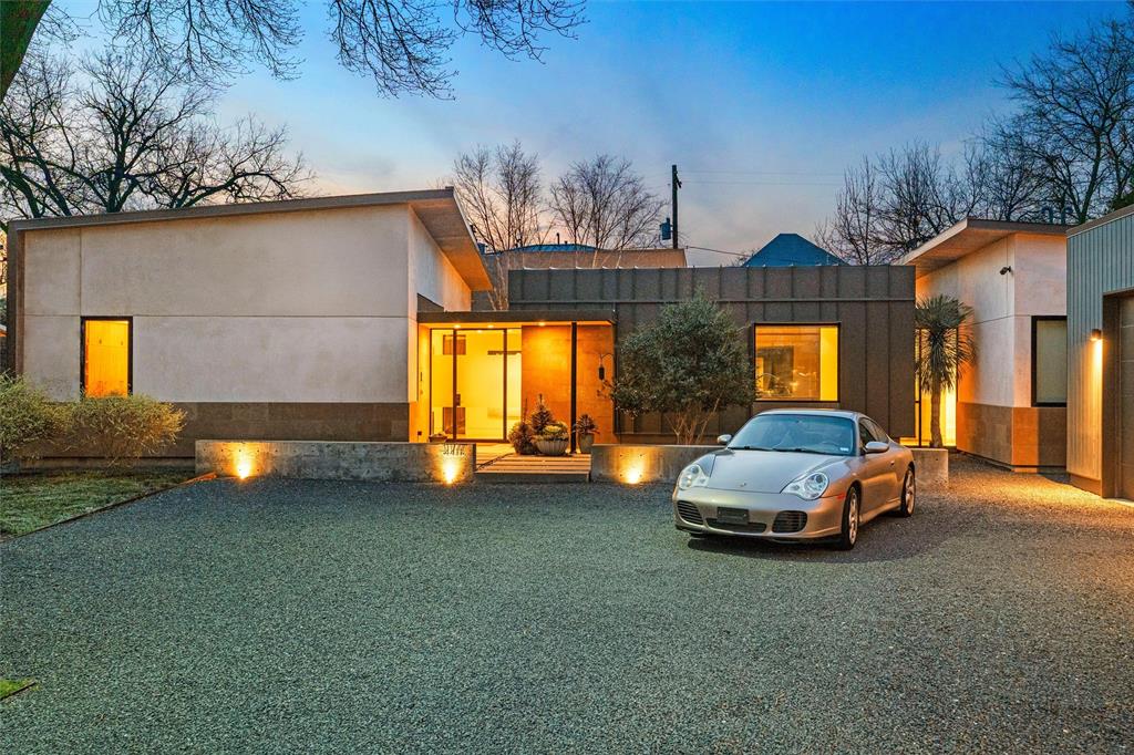 Designed by award winning architects Mitchell and Garman, this striking modern residence features five interconnected structures arranged around a tranquil courtyard and resort style pool, creating complete privacy in the heart of Dallas. Glass corridors, a standing seam metal roof, and expansive steel framed windows bring in natural light while maintaining a strong connection between indoor and outdoor living. Sophisticated interiors include open living spaces with polished concrete floors, walnut cabinetry, custom millwork, and a sleek fireplace. The chef’s kitchen offers an oversized island, Wolf appliances, a 70 bottle Sub Zero wine refrigerator, and generous seating for gathering and entertaining. The primary suite provides a peaceful retreat with garden views and spa inspired finishes, while two secondary bedrooms with ensuite baths sit on the first floor. Upstairs includes two additional bedrooms and a flexible second living area. Smart home features include a Control4 system supporting comfort, lighting, climate, and security throughout the home, while multiple outdoor living areas extend the living space into the beautifully designed grounds. A screened in patio with fireplace creates a comfortable setting for year round enjoyment, while sculptural landscaping, a water feature, and thoughtfully designed courtyard spaces create a calm Zen like atmosphere throughout the property. A three car garage and gravel drive complete this architectural masterpiece set within one of Dallas’s most desirable locations.