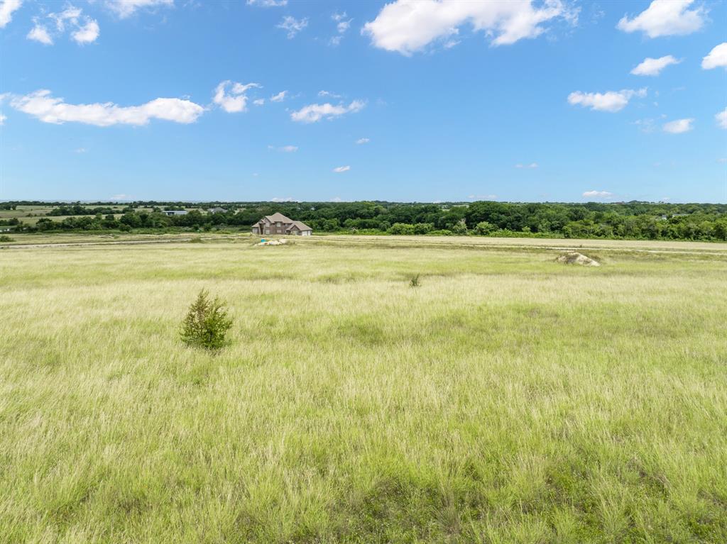 Discover the hidden beauty in one of the best kept secret rural communities South of the Metroplex! Take a visual journey into rolling hills and open pastures. This 2 plus acre homesite has an elevated hilltop view of the Western sky, perfect for experiencing the most scenic sunset views.   A rural retreat with a peaceful, quiet setting and solid ground for building. Hill Creek Ranch is located between I-35E & I-35W making a quick commute to DFW or Waco easy.  Countryside views with quick easy access to Buccees, restaurants, and shopping.  No gravel roads means your car stays clean!