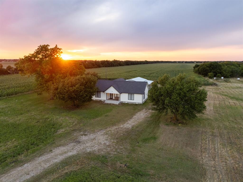 Pull on your cowboy boots — we're headed to West, Texas. An extraordinary renovated farmhouse on over 8 acres, just 15 minutes north of Waco.The scenic drive out sets the tone for everything that awaits beyond the front gate. Two stock ponds offer peaceful mornings and golden-hour evenings perfect for fishing or hunting for crawdads. The multipurpose metal pavilion features bay doors on all sides, a wraparound covered porch, insulated ceiling, ceiling fans, and heaters — built for every season. A fire pit and outdoor lighting complete a setup ready for entertaining or unwinding under the Texas sky.Step inside and prepare to be surprised. This home has undergone a complete renovation that shows in every room. New plank flooring throughout, custom cabinets, and engineered stone countertops in every bathroom and the kitchen. The kitchen is a standout — propane stove, farm sink, reverse osmosis purifier, and an island with seating for seven.Two master bedrooms each offer a private ensuite and walk-in closet. All three bathrooms are fully renovated with new tile, fixtures, and anti-fog LED mirrors. A new electrical panel, tankless water heater, upgraded plumbing, and Nest Smart Home features round out the infrastructure upgrades. Outside, new Hardie-style shingle siding and fresh exterior paint give the home curb appeal to match its stunning interior.This is your Texas country escape — big sunsets, open land, modern comfort, and the kind of peace that's getting harder to find. Come see it before its gone.