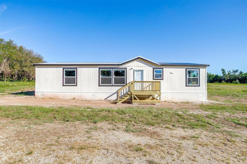 Beautiful double-wide mobile home situated on a spacious 1-acre lot, offering a blend of durability, comfort, and modern features. The exterior includes a 29-gauge metal roof, Hardie fascia board, and vinyl soffit for long-lasting, low-maintenance appeal.  Interior features include 8-foot sidewalls, 16” on-center floor joists, and 2’ x 4’ marriage walls, providing added structural integrity. The kitchen offers rolled countertops with backsplash, LED recessed lighting, and a ceiling fan. Decorative plumbing fixtures are installed throughout the home.  The primary bathroom includes dual vanity sinks for added convenience. A 50-gallon water heater ensures ample hot water supply.  A new caliche driveway was recently added too.  Located on a generous lot with room to enjoy outdoor living. Schedule your showing today!